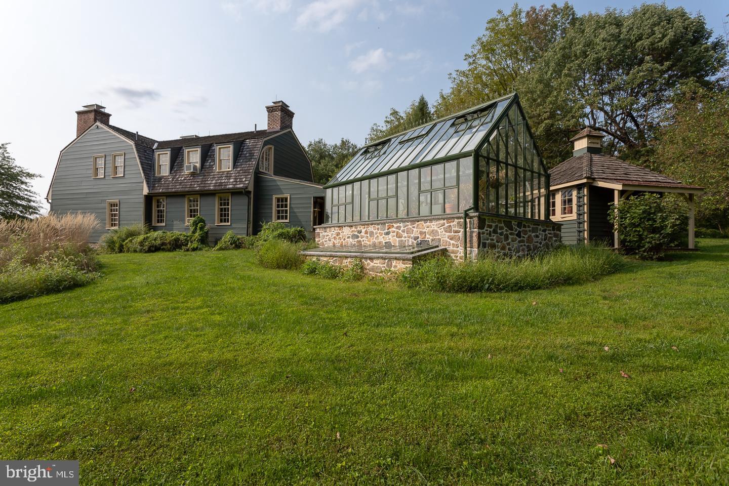 One-of-a-kind sanctuary in Chester Springs. This lovely 6+ acre parcel boasts the Hamilton House, a Dutch Colonial style which dates back to 1751 and was moved and reassembled here from Charlestown, MD in 1991. Modern updates and amenities combine with historic features for this unique home set high on a hillside with views and wonderful natural light in every direction. On the first floor find a modern eat-in kitchen with a fireplace that perfectly compliments the historic elements on this level which include a large living & sitting room, dining room with nook, office and den. You?ll also find a laundry and powder room on the first floor. On the second level, find the master suite with private bath, beautiful window views and a custom fireplace. Three additional bedrooms, 2 full baths and a dressing room complete this floor. The unfinished basement functions as a game room & workout space. While updated with modern amenities, many historic elements are maintained including 8 total fireplaces, original floors, millwork and hardware, there are even candle marks that had been burned into the original wood. Step outside to enjoy meandering paths, cottage gardens or the covered stone patio. Property also includes a modern two-story 2000+ sq ft barn built in 2003, which functions as a guest house, entertainment space, home office and studio! Beautifully designed with fieldstone and cedar plank, the interior has an thee levels of living space with an open floor plan, beautiful two-story fireplace, kitchenette and full bath. Enjoy the sunset from the covered front porch with yet another fireplace. There is a 3-car garage built with matching materials to the barn which features significant storage. Other outbuildings include an amazing greenhouse, a horticulturalist's dream with too many features to mention and everything you need! The grounds are beautiful with a combination of untamed moments and manicured spaces to produce views and privacy in throughout the property. Head down to the lower gardens or the path through a carefully designed wooded landscape. This perfect paradise could be your forever home! Well-located in a high end neighborhood with easy commute options and access to all major amenities and roadways.