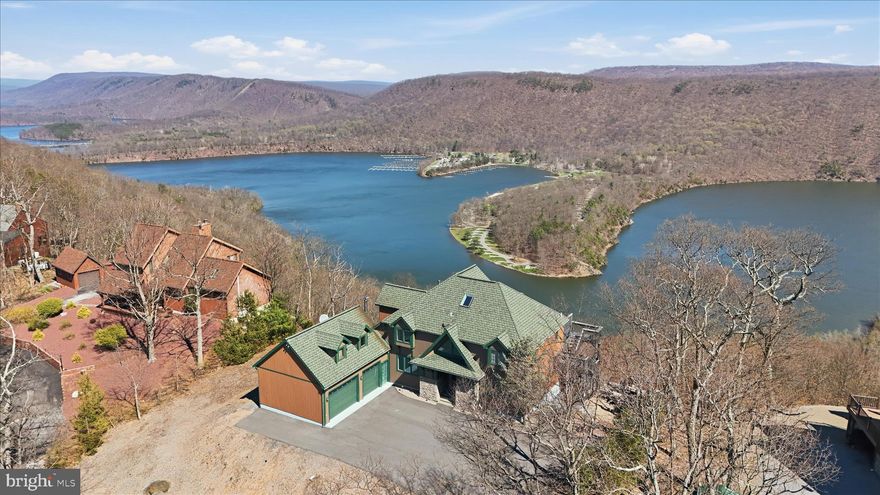 ONCE-IN-A-DECADE OPPORTUNITY

1 of Only 31 Homes with Direct Views of Raystown Lake

Offering what may be one of the most breathtaking vantage points in all of Pennsylvania, this extraordinary residence captures the lake, mountains, and rolling valleys in a way that simply cannot be replicated.

Nestled within the prestigious enclave of Shy Beaver Lakeview Estates, this exceptional 6-bedroom, 3.5-bath home masterfully blends luxury, comfort, and proven income performance into one remarkable offering. Originally built in 1998 and fully renovated in 2022, the property has been thoughtfully reimagined with upscale finishes, refined design, and high-end furnishings—all included—creating a true turnkey experience.

Inside, rich hardwood flooring flows through a bright, open layout filled with natural light. The eat-in kitchen and breakfast area, enhanced by skylights above, serve as the heart of the home—effortlessly connecting to inviting living spaces designed for both entertaining and everyday comfort. Spa-inspired bathrooms and renovated tile showers elevate the interior, while every detail reflects a balance of warmth and sophistication.

The primary suite offers a private retreat, featuring a calming atmosphere designed for rest, recharge, and quiet escape. It also boasts a spacious walk-in closet and abundant storage, providing both luxury and functionality.
Two bedrooms are elegantly positioned with private walkout access to a second-story deck, creating a seamless indoor-outdoor experience and offering a refined vantage point to enjoy the property’s natural beauty in complete privacy.

Step outside and the experience only deepens.

Set on 1.3 meticulously landscaped acres, the property showcases extensive hardscaping, stone retaining walls, and a rare fully paved driveway. An expansive deck and heated hot tub are perfectly positioned to take in the surrounding beauty, while the home’s location—just 500 feet from the water and moments from the boat launch—provides effortless access to everything Raystown Lake has to offer.

What truly sets this property apart is its identity as a fully operational, high-performing luxury short-term rental. With five-star reviews on Airbnb and VRBO and a proven track record generating approximately $100,000 to $135,000 annually, this home offers immediate income potential with seamless, turnkey management options.

Adding yet another layer of rarity, the property is directly bordered by thousands of acres of federal land, ensuring lasting privacy, protected surroundings, and endless opportunities for outdoor adventure.

Whether your days are spent boating on the lake, hunting, hiking, biking, or simply unwinding above it all, this home delivers an experience that is both invigorating and deeply peaceful.

With an oversized attached garage, ample parking, premium furnishings included, and a location that merges lake views, federal land, and investment performance, this is more than a home.

It is a luxury retreat.
An income-producing asset.
A legacy property meant to be experienced—and held.