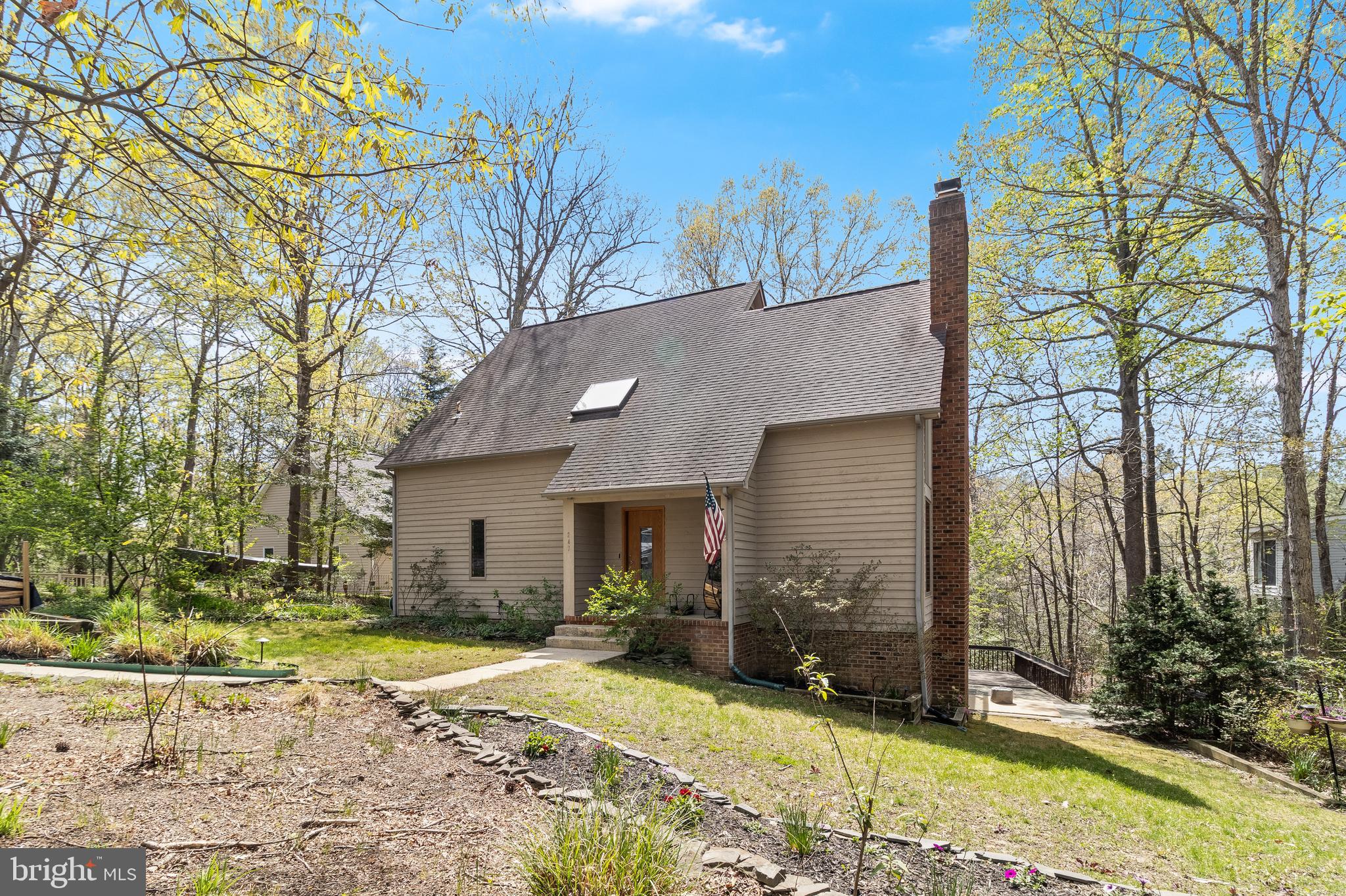 A home like something out of a novel. A charming contemporary style house with views of Mill Creek glistening from each level. Even though this home comes with a private pier it's just walking distance from the local Marina! The centerpiece of the house is a stone covered two-story wood burning stove surrounded by large windows which makes for a warm welcome each time you step into your home. The main bedroom leads you out back where you will find expansive multiple decks and outdoor seating areas that are perfect for entertaining! More recent updates include a remodeled kitchen with stainless steel appliances and wall ovens and bathrooms with ceramic tile flooring. The primary bathroom equipped with a walk-in tiled shower and overhead rain style shower head.
Head upstairs to your cozy loft lit with abundant natural lighting from the skylight above. The remaining bedrooms have large windows and a balcony for all to look out and enjoy the scenic views of the surrounding woods and water.
In the walk-out level basement you will find an additional wood fire place. A separate bar with sink and a large open area and the sliding glass door which leads you out to the beautiful stone patio sitting area and walk way down to the private pier!