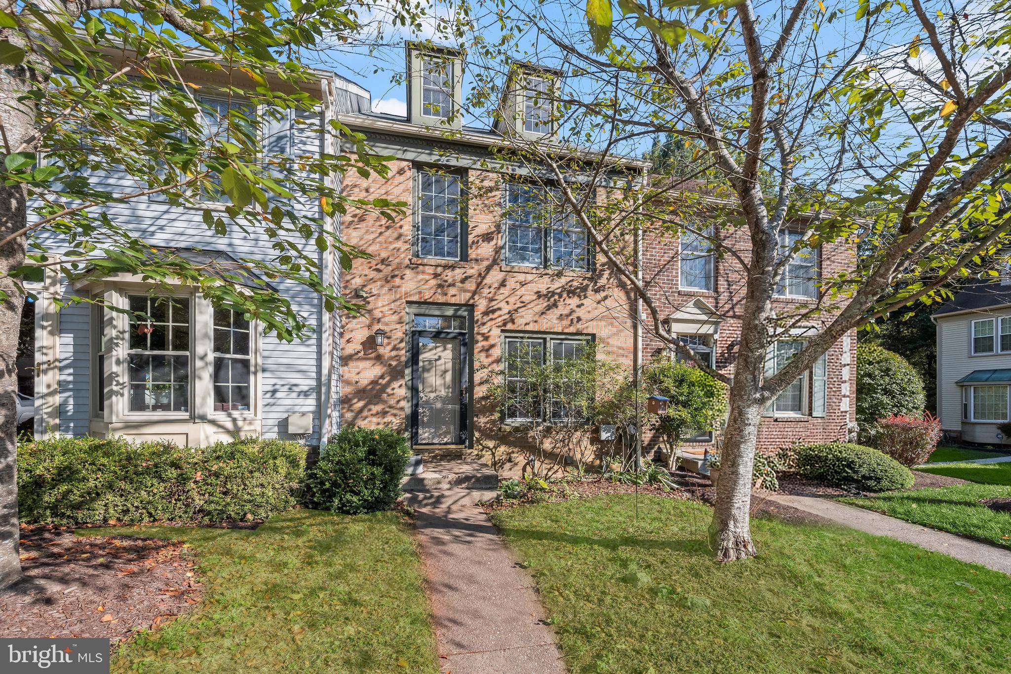 Beautiful brick-front townhouse in the sought-after Dorsey Hall community combines thoughtful updates with a setting that feels both peaceful and connected. Nestled in a tree-lined neighborhood that backs to wooded views and winding community trails, the home offers easy access to a playground, park, pool, and basketball court, all while maintaining a tranquil atmosphere. Step inside and to the right is the kitchen, featuring stainless steel appliances, granite counters, and a generous pass-through window that opens to the dining room, making everyday meals and entertaining effortless. Hardwood flooring stretches across the main level, seamlessly uniting the dining and living spaces. In the living room, a cozy fireplace anchors the space, while an atrium door invites you out to a spacious deck, perfect for enjoying the peaceful backdrop of trees. Upstairs, three bedrooms provide comfort and versatility. The primary suite impresses with soaring two-story ceilings, abundant windows, two closets, and an en-suite bath with a granite counter comfort-height vanity. A private loft adds another dimension to this retreat, creating a flexible space ideal for a home office or reading nook. Two additional bedrooms and a full bath complete the upper level. The lower level is equally inviting, with wide-planked cork flooring in the family room and a sliding glass door that opens to the patio for easy indoor-outdoor living. A versatile bonus room, a utility space with laundry, and ample storage round out this level. Recent updates provide peace of mind, including a new roof and skylights in 2022, a heat pump in 2021, attic insulation in 2021, lower-level cork plank flooring, and a washer added in 2024. With a convenient commuter location close to major highways, shopping, dining, and everyday needs, this townhouse balances convenience with comfort. As part of the Columbia Association, residents can enjoy a wealth of community amenities, including pools, recreational facilities, and trails, making this home an exceptional opportunity in Dorsey Hall.