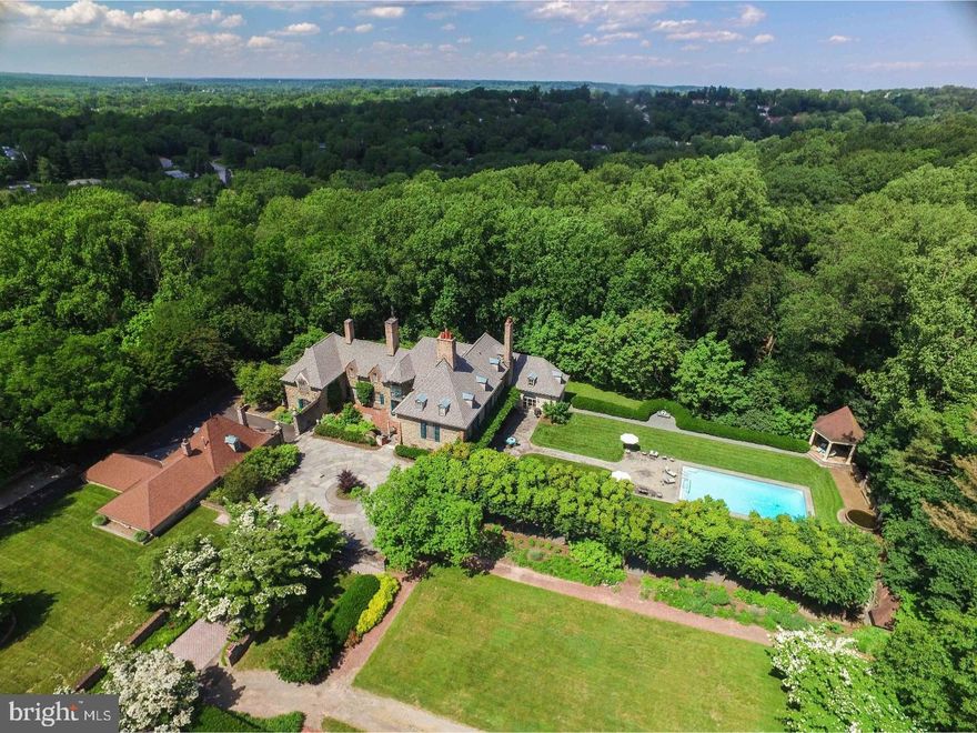 "Ropsley" is an architecturally significant, one-of-a-kind four-acre country estate designed by Mellor, Meigs & Howe in 1917, in the desirable Wyndmoor neighborhood. Tucked behind winding stone walls, the entire arrangement of rooms, forecourt, gardens and service courts were designed with the compass in mind, highlighted by the compass in a beautiful mosaic on the floor of the great hall. This exceptionally thought-out home includes sight lines designed in order to present the most pleasing views from each room. The level at which the main floor is set offers dramatic views of the parterre and grounds with mature trees and landscaping. The home was completely updated and restored by the current owners and is replete with many original details and all modern systems. Upon entering the rotunda, with a dramatic circular staircase forming the center of the house, you are immediately struck by the exquisite craftsmanship and detail. The great hall with hand-carved stone mantle, original timber framed ceiling, and Enfield tile floor leads to the wood-paneled drawing room with full bath. Floor-to-ceiling windows look out on the stately terraces and pool. The dining room with built-ins and fireplace provides the perfect space for more formal entertaining, while the family room with vaulted ceiling and corner fireplace offers a respite for cozy gatherings. The kitchen with vaulted 2-story ceiling and large center island with adjacent, sunlit morning room will quickly become a go-to spot for coffee overlooking the rear grounds. Upstairs, the master wing offers a large master bath with pretty views of the property, a convenient study and laundry, and a large, adjoining bedroom with en suite bath. The second floor living room offers access to the separate in-law or au pair suite, with full, eat-in kitchen, full hall bath and two bedrooms. The third floor of this home offers a large bedroom with a living area with kitchenette and second laundry. There are two additional cottages on the property, perfect for extended family or rentals. Located just minutes from regional rail, major highways and the shopping and restaurants of Chestnut Hill. Ropsley is a truly spectacular estate.