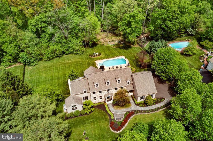 Welcome to the Buckingham neighborhood of Coldbrook, where wide winding roads are lined with mature shade trees. This impressive stone-front Colonial home spans over 4,500 sq.ft. of living space and was masterfully constructed by Zaveta in 1993, and then beautifully re-built by Zaveta in 2011. Stacked stone neatly edges the gardens along the slate walkway leading to a courtyard entrance with covered portico. Classic design never goes out of style, especially when natural light is introduced along with an open floorplan. The 2-story center hall foyer with turned wood staircase is flanked by the formal living room and dining room. Architectural details define rooms that flow effortlessly into the next, each with extensive millwork and hardwood floors. A gas fireplace surrounded by built-in shelving may be enjoyed from many vantage points, including the stunning gourmet kitchen. Any cook will delight in the abundance of warm wood cabinetry, a double sink with commercial faucet, granite peninsula and island - both with overhangs for seating. Stainless steel appliances include a built-in Sub-Zero refrigerator with glass door and an undercounter beverage cooler. A Mercer tile inlay adorns the backsplash behind the Wolf professional range and hood. Around the corner, walls of windows in the sunroom provide spectacular views of the extensive outdoor living areas with a wooded backdrop. A voluminous ceiling and full-sized wet bar with seating and wine refrigeration creates a great place to host either large or intimate gatherings. Palladium doors opening to the covered patio, along with a back door entrance near the laundry room and a full bathroom make pool parties a must! The sparkling pool with spa is surrounded by lush plantings and a wrought iron fence. Back inside, the cozy family room offers a stone fireplace with raised hearth and sliding glass doors leading to a paver patio. French doors on the other side of the family room open into the first floor office, where a vaulted ceiling and sunburst window offer a cheerful room to concentrate. Front or back staircases lead to the generously-sized bedrooms including an expansive owner's suite with professional organization system in the walk-in closet, and a luxurious bathroom with jetted soaking tub, separate stall shower with seamless glass enclosure, double sinks, and a water closet. The Prince/Princess suite features a dedicated bathroom and a walk-in closet. The remaining three bedrooms on this floor are all nicely-sized with ample closet space, and share the full bathroom accessed from the hallway. Additional living and entertaining space may be found on the lower level. The theater room provides tiered levels for the lounge chair seating that allows everyone to watch a movie on the overhead projector in comfort! Separate rooms for gaming or exercising, along with a bonus room and a full bathroom, are also located on this level – and still plenty of utility and storage space left over. Need a change of scenery? A trail in the back woods leads into Maplewood Park, and eventually Doylestown Borough! This coveted location is just minutes into historic Doylestown Borough with shopping, dining and cultural attractions, and has easy access to major commuter routes to New York, Princeton and Philadelphia. Located in the award-winning Central Bucks School District.