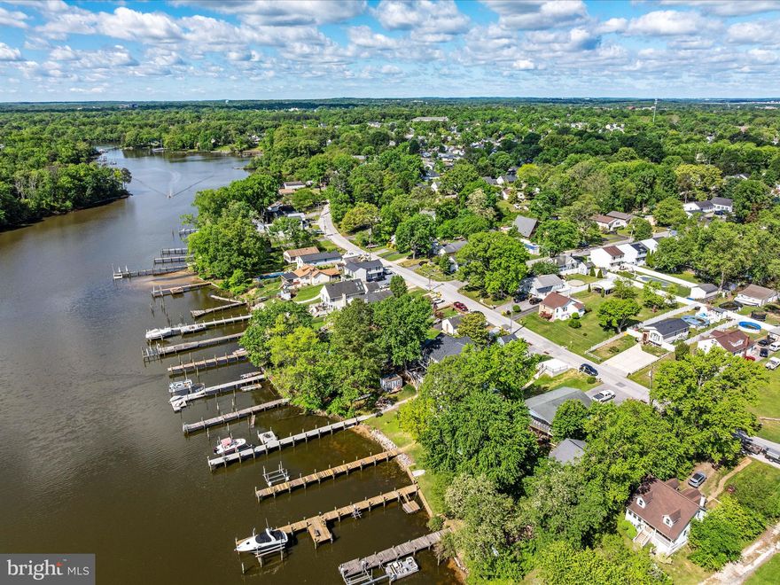 Welcome to 7847 Leymar Road — a beautifully renovated, single-level waterfront residence offering effortless living, timeless style, and a setting that is nothing short of captivating. Perfectly sited on a quiet, protected creek with quick access to open Bay waters and the significant advantage of no flood-zone concerns, this home combines refined design with the relaxed ease of coastal living. From the moment you enter, soft natural light and wide water views create an atmosphere of calm and understated luxury.
The open-concept living space is thoughtfully designed for both everyday comfort and elegant entertaining, featuring a stunning chef’s kitchen with quartz countertops, custom cabinetry, stainless appliances, and an oversized island that naturally draws guests together. The primary suite enjoys serene waterfront views and a spa-inspired bath, while two additional bedrooms and an updated full bath offer ideal versatility for guests, a home office, or family.  Outdoor living is where this property truly shines. A private pier with water and electric provides multiple slips for boats, jet skis, and kayaks, creating an effortless gateway to quiet sunrise paddles, midday explorations, or leisurely afternoons on the water. The expansive deck and beautifully maintained yard extend the living space outdoors, offering the perfect backdrop for waterfront dining, weekend gatherings, and peaceful evenings as the sky shifts through shades of gold and rose.
Nestled within a warm, welcoming waterfront community where neighbors wave, boats idle by, and life naturally slows to a more enjoyable pace, this home offers a lifestyle that feels both elevated and deeply comforting. With its thoughtful renovations, low-maintenance features, and rare combination of privacy, water access, and style, 7847 Leymar Road stands out as a turn-key opportunity to experience the best of Maryland waterfront living.  Homes of this quality and simplicity of lifestyle are uncommon. A private tour is essential to fully appreciate the light, the views, the flow, and the quiet beauty that define this exceptional property.