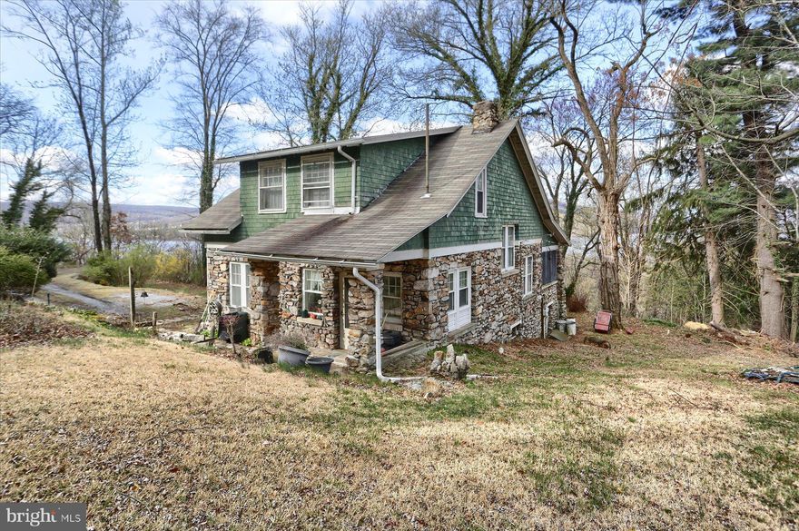 A panoramic view of the beautiful Susquehanna River on these four acres is available for new owners to enjoy living with nature on this hillside just minutes from the excitement of the capital city's rich history, regional arts, dining and entertainment.  This natural light-filled, well loved home could be a seasonal retreat or a place to call home all year round.  As the saying goes and has welcomed so many family and friends over the years, this BACK DOOR entry leads to an eat in kitchen with original built in glass door cabinetry and adjoins the a more formal dining room area. The gathering room features a focal fireplace with insert for those chilly fall to spring evenings. A connecting sunroom could be a home office area, toy space or reading room.  With its wide window sills, house plants thrive there and starters from seeds would receive the sun.  From there access a seasonal screened porch for often viewing the sun's magnificent colors to the West. Three bedrooms, all featuring walk in closets, and an updated bathroom are accessed from an open stairway and complete the 2nd floor footprint.  Being sold AS IS.