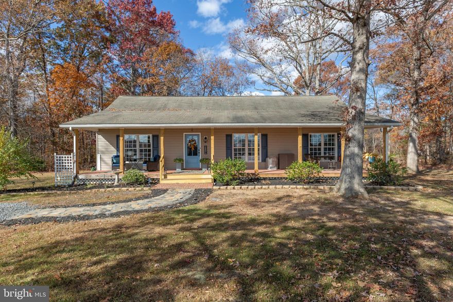 A scenic slice of Orange County awaits at 28896 Horseshoe Road, where modern comfort meets country serenity across nearly three acres! Built in 2004 and beautifully updated inside and out, this three-bedroom, two-bath rambler spans 1,456 square feet and shines with updates, views and everyday ease. Set on 2.75 acres, the property stretches wide and flat, framed by mature oak trees and a stone driveway. From the deep eight-foot front porch (complete with a swing!) It’s easy to see why the owners fell in love here: the ridge and neighboring farmland unfold in full view, particularly breathtaking during sunrises and autumn’s changing colors. Out back, the shaded yard holds an approximately 14-by-12 deck off the kitchen, several hydrangeas and hostas and a 20-by-10 Amish-built shed added in 2022, outfitted with double doors, windows and custom benches. Two motion lights with SD card storage provide peace of mind. As for the residence itself, the tan siding with navy shutters and light blue front door keep curb appeal classic. Inside, the home has been nearly taken down to the studs and rebuilt with a polished, move-in-ready finish! LVP flooring runs throughout, complementing a welcoming foyer and spacious 14-by-17 living room anchored by a ventless gas fireplace with a raw-wood mantle and sconce lighting. The floor plan splits from here, with a reimagined primary suite to the right. The space flows through a dressing area with dual closets into a custom ensuite bath featuring a tiled shower with rain head and bench, a new vanity and a bidet-equipped toilet. The kitchen - running nearly the length of the living room - includes stainless steel GE double ovens, butcher-block counters, custom white and navy cabinetry with rollouts and racks and a peninsula for extra prep and storage. Off this area sits the laundry/utility room with cabinetry, wallpaper accent wall and newer appliances. Both secondary bedrooms are freshly painted with new doors and trim, sharing a renovated hall bath that mirrors
the home’s style and upgrades. Recent system updates include a new HVAC system (May 2024), hot water heater (2022), front porch posts, stone walkway and fresh interior and exterior paint – it shows, folks!
Conveniently located within 20 minutes of downtown Culpeper and 25 minutes from both downtown Orange and the Route 3 shopping corridor, 28896 Horseshoe Road offers country calm without sacrificing convenience. Book your showing of this turnkey retreat ASAP!
