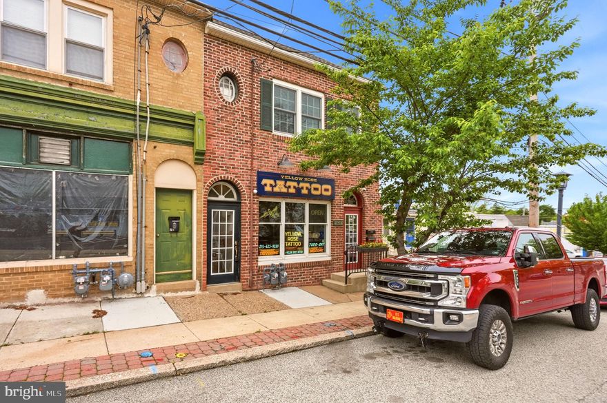 Opportunity knocks for investors and owner-occupants alike with this well-maintained brick and stucco mixed-use duplex/retail property in highly desirable Glenside! Offering excellent visibility and a prime location, this versatile property is perfect for generating income while enjoying the convenience of living and working in one place.
The first-floor commercial space is currently operating as a Tattoo Parlor  and features an open layout with a reception area, private back office, half bath, and direct access to the basement. Ideal for a variety of retail or professional uses.  Currently leased till 2029.
The second-floor apartment is a beautifully updated contemporary 2-bedroom unit with separate front and rear entrances. Inside, you’ll find soaring vaulted ceilings with skylights, newer hardwood flooring in main living area, wall-to-wall carpeting in bedrooms, and an updated ceramic tile bathroom. The spacious eat-in kitchen boasts hardwood flooring, expansive countertop space, abundant raised-panel white cabinetry, dishwasher, gas range/oven, and integrated microwave. Sliding doors lead to a private rear deck, perfect for relaxing or entertaining.
Basement offers lots of storage and laundry access from both main floor unit and outside entrance.  
Current rental income offers strong cash flow potential with approximately $925/month from the retail space, and potential of $1800-2,000/mo for the apartment. Whether you’re looking for an investment property or a live/work opportunity, this property delivers value, flexibility, and income potential. Oh and the Roof was replaced in 2022!  Don’t miss this lucky find — the numbers work, and the building is move-in ready!