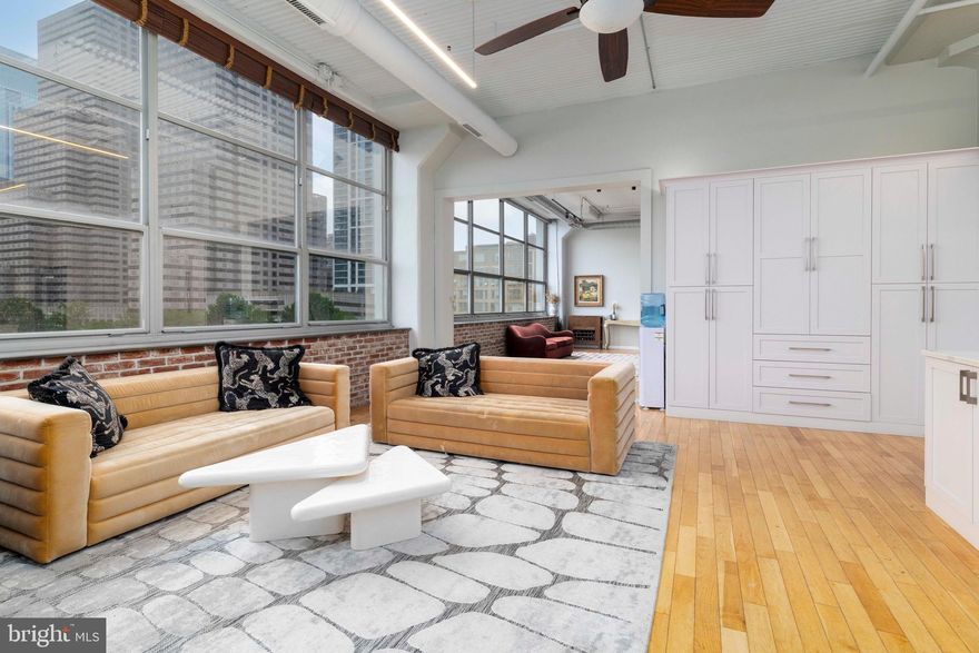 Sophistication reimagined at this stunning double unit at the Larkin in Logan Square. Step into this expansive, fully-renovated space with soaring (14 ft) ceilings, hardwood floors, an unbelievable amount of built-in storage and endless city views. With more than 2600 square feet of functional living space, this four bedroom, four bath (FULL and en suite) unit will be your refuge from the city hustle and bustle. One of the bedrooms is a loft that can alternatively be used as a workspace or den (and yes, there is a full, en suite bath!). The kitchen with its gorgeous, over-sized stone island and extensive, custom cabinetry,  is the heart of the unit. There is a built-in banquette next to the kitchen that allows for additional dining options while preserving the flow of the space. And tucked away in the living area cabinetry is a second refrigerator. This is so handy for guest beverages or for the kids. The sliding barn door can divide the living and dining space, but while open, allows for panoramic light throughout the main living space from the wall of windows. Three of the bedrooms (with en suite baths and closets) are fully enclosed and provide the perfect space for a peaceful rest. Unit 506-507 boasts TWO laundry rooms and also TWO AC units to ensure comfort throughout. What else could this stunning unit offer? Parking for TWO cars in the attached garage. Schedule your appointment today to see this designer unit at the Larkin!
The Larkin is a historic, full-service New York-style loft building that offers amazing amenities and has one of the most dynamic locations in Center City. Just a short walk from Rittenhouse Square, 30th St Station, Aramark, Morgan Lewis, Schuylkill Yards, Chubb Insurance, the Schuylkill River Trail and the Parkway, everything you need for is within a few blocks. Adding to the convenience are Trader Joe’s and the new Giant Riverwalk, which are directly across the street. This home is within the Greenfield Catchment.