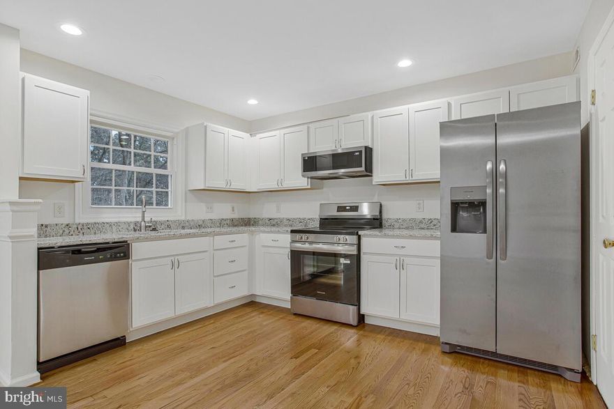 Renovated and priced to sell in Seven Oaks! This end-of-row colonial townhome offers 3 finished levels.  The top level consists of 2 primary ensuites with brand new custom tiled baths.  The main level includes a modern kitchen with new stainless steel appliances and granite countertops.  Refinished hardwood floors are found throughout the main level.  The walk-out lower level with full bath is ideal for a family room, home office, guest space, or workout room. Enjoy cozy evenings by the fireplace and outdoor time on the recently refinished rear deck with new posts, steps and decking—providing flexible living for today’s lifestyle..  Located in the highly desirable Seven Oaks community, this home is minutes to Fort Meade, NSA, MARC train, shopping, dining, and major commuter routes—perfect for buyers seeking convenience without sacrificing neighborhood feel. Two assigned parking spots and a low monthly HOA make everyday living easy.  Freshly painted with new carpet.  A must see - schedule your showing today.  Make 2144 Commissary Cirxle your Home Sweet Home.