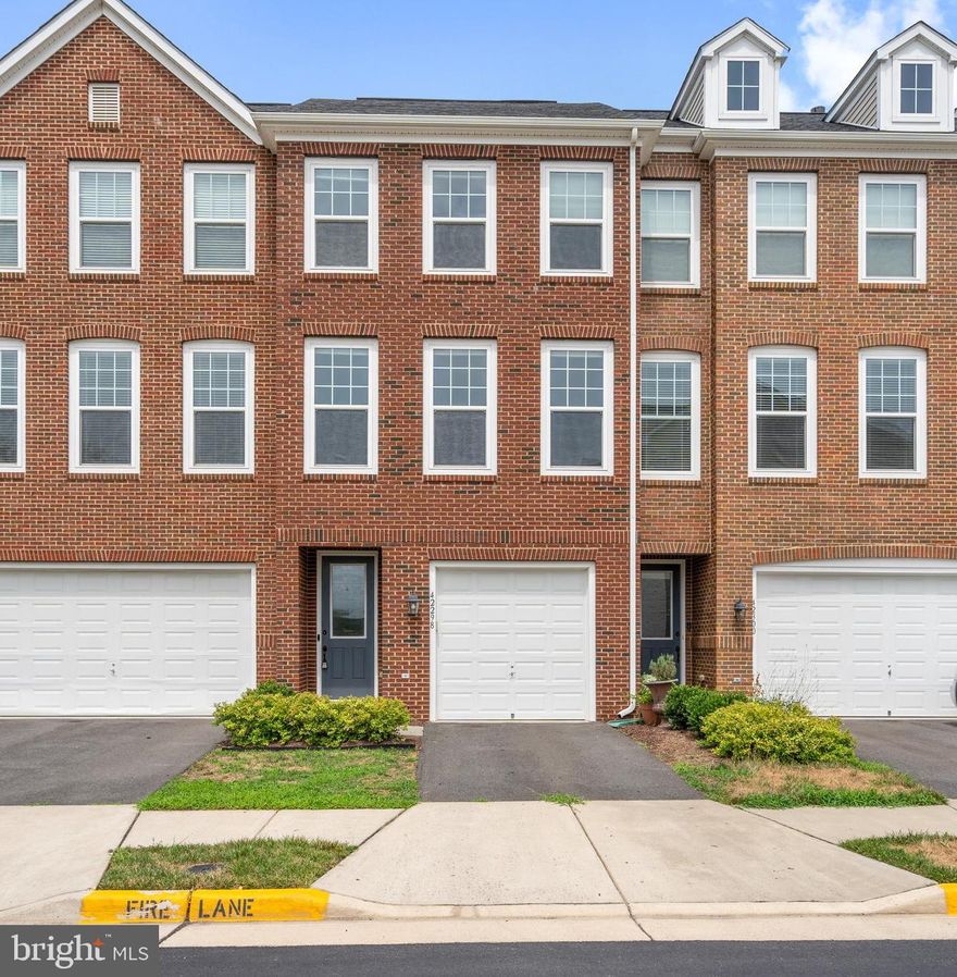 Stunning 3-bedroom, 2.5-bath townhome with a garage in the sought-after Eastview at Stone Ridge community. This modern Van Metre townhome features an inviting brick façade and easy-care landscaping. The lower level offers a versatile bedroom or office. The main floor includes a spacious, sunlit living room, a kitchen with gourmet upgrades, a half bath, and a dining room with direct access to a low-maintenance composite deck. The kitchen boasts stainless steel appliances and granite countertops. The upper level hosts a primary suite with an ensuite bathroom featuring a soaking tub and a walk-in closet. The second bedroom also includes an ensuite bathroom and walk-in closet, with laundry conveniently located between the bedrooms. Located in the vibrant Stone Ridge community, this home is near the Village Center, Stone Springs Hospital, and Gum Springs Library, with easy access to major commuter routes, Dulles Airport, shops, and restaurants. Stone Ridge amenities include walking paths, a tot lot, outdoor pools, a clubhouse, fitness center, indoor jogging track, rock climbing wall, and various sports courts. Byrne Ridge County Park, at the heart of the community, offers 26 acres of trails, batting cages, concessions, and fields for baseball, football, lacrosse, soccer, and softball. Loudoun County transit services connect park and ride lots in Stone Ridge to Metro Stations.