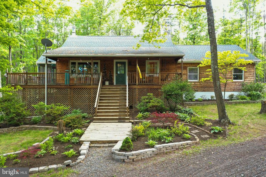 Price reduced! Well-maintained, rustic cabin in the woods, offering all the privacy you are looking for! Beautiful wooden ceilings, exposed beams, and attractive hardwood flooring. Expansive dining room/library and two pantries (one large, one extra large!). This home was renovated in 2017 and the new restful primary bedroom suite was added that same year. HVAC replaced in 2018 and roof, gutters, and siding replaced in 2017. Enjoy the outdoors from your two patios, wraparound deck, or screened in porch. The attached garage has stairs to a storage area above, and there is also a giant detached garage (roughly 20' x 40') with electricity, and a chicken coop! This property includes two lots (18 & 19) with the potential to add a second home on the other lot, as the home is built entirely on Lot 19. There is also deer fencing around the entire property which keeps deer out very well. As a resident of the desirable Sleepy Creek Farms neighborhood, you will be able to fish in the neighborhood ponds! And all of this on 6.9 acres in beautiful Berkeley Springs, less than ten miles from Cacapon Resort State Park and Sleepy Creek Wildlife Management Area. Schedule your showing today!