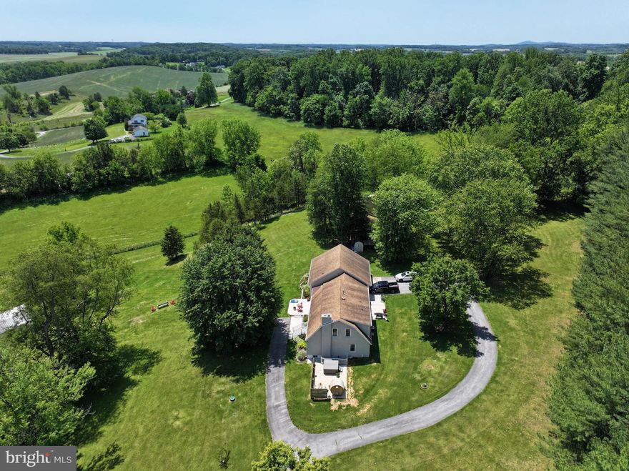 Amazing estate in beautiful Mount Airy with 5 bedrooms and 5 1/2 baths home on 6.7 breathtaking acres! This home was renovated in 2020 and has had numerous more recent upgrades.  The kitchen features a new stainless steel Cafe dishwasher, built in Cafe microwave, and LG stove, an expansive kitchen island and generous cabinetry. You'll love the sweeping views from the bay window over the farm sink. The home is great for entertaining in the spacious living room, dining area and comfy family room. The main level primary suite has a working fireplace, electric window darkening shades, custom wood trim, full bath and large walk in closet. The upper level has three additional bedrooms including a 2nd primary suite. The basement was finished in 2023 and has a rec room, bedroom and full bath. The property is completely fenced and has a solar powered gate that can be controlled remotely. You'll love the outdoor features including Hardy plank siding, cedar wrapped porch, hot tub, SISU sauna, outdoor TV and speakers, and stone fire pit. There is a 3 bay pole barn, a rustic barn and chicken coop (chickens convey if buyer wishes). Sellers had dedicated wired Internet cable installed and a Level 2 Rapid Charger for electric vehicles. The home also includes a whole house generator.