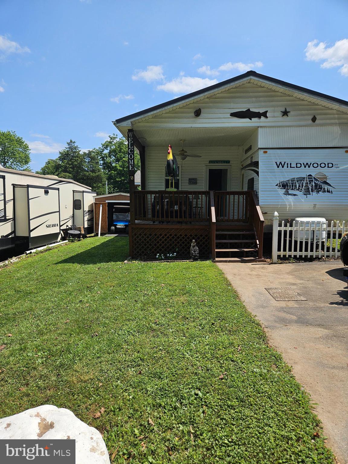 Welcome to Riverbends Block 11 Lot 16 Hot Springs Ave on SEWER in Riverbends Rv Campground. Riverbend is 400 Acres of SEASONAL recreational campground full of amenities located on the Potomac River in Falling Waters, Wv. OPEN APRIL 1 - NOVEMBER 1 - This is a fun & entertaining community, yet relaxing.
Block 11 Lot 16 includes a well taken care of 2008 Wildwood camper that has 2 bedrooms (One on each end of the camper) One is a Queen size with lots of storage space and desk area and the other has a twin bed and a half bath with its own entry way. In the kitchen you'll find a full size refrigerator, extra appliances and more. This camper also has a tub / stall shower and a standard toilet. Attached is a beautiful 21 * 11 bonus / living room, and a 7 * 8 Laundry room with a full-sized stackable washer and dryer built on to it giving extra living space to spend the entire season here or just for the camping weekends and can invite your friends and family in. Almost everything you see conveys including the 36 V Electric golf cart and 2 chargers and a shed with electric. Spend your mornings on the 12 * 8.5 covered porch with a fan to keep the air moving or wind down your evenings out here. Perfect flat yard and paved driveway large enough for 2 vehicles. You aren't going to want to pass up this one. Schedule your showing today!
Bring your camping chairs to make smores and memories here around a campfire. This is the spot! Approx. 10 miles of Deep water on the Potomac River access for boating, fishing & swimming. Yearly membership ($1,775) plus a $200 initiation fee for new owners, includes water, this one is on sewer, electric, trash and the park amenities such as 3 pools, putt putt course, Horseshoe club, Boat club, Poker runs, Trick or Treat, Christmas in July, live bands, basketball court, tennis court, fireworks, car show, Church, restaurant, bar, convenience store (Great food), playground, volleyball, ball field and much much more. Bring your golf carts, water toys and come enjoy life!