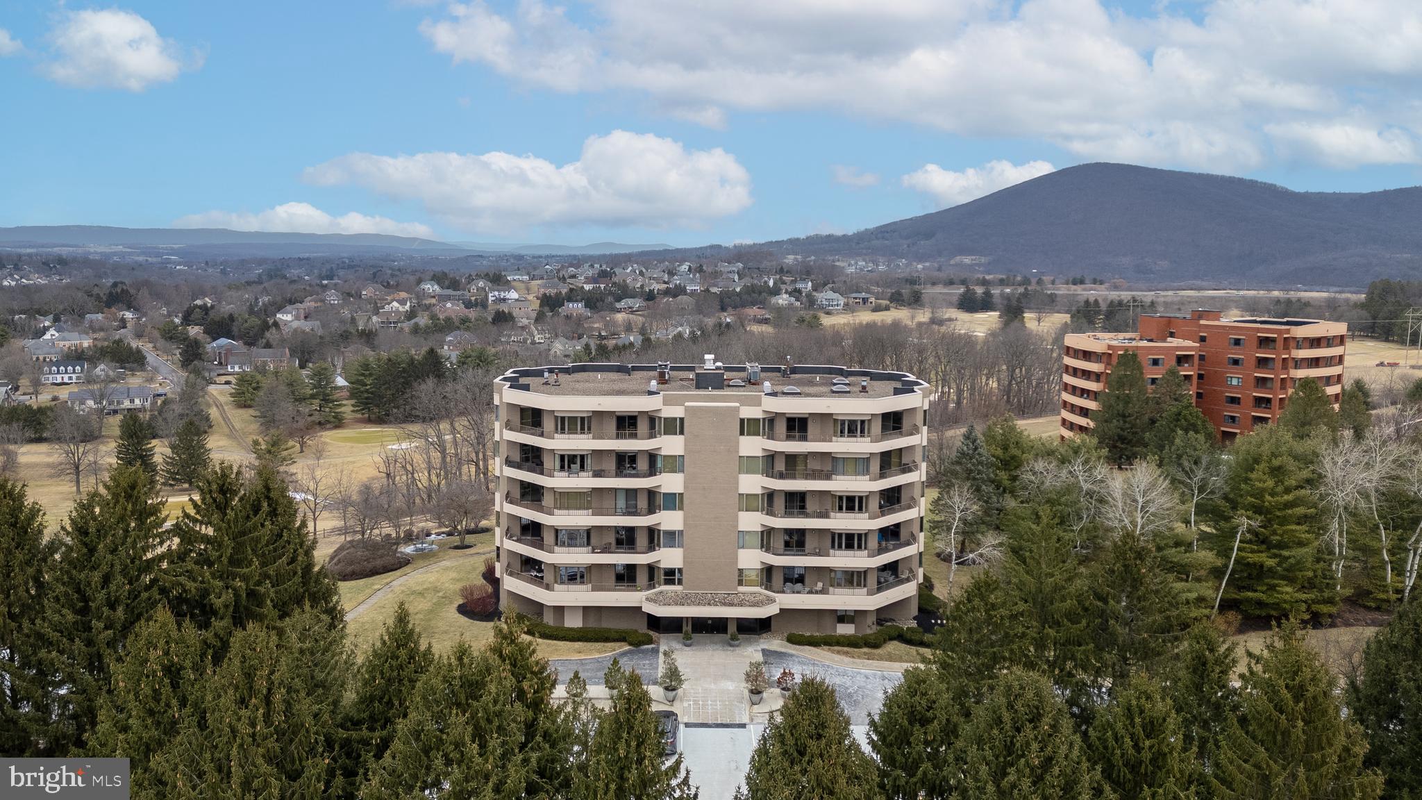 This condominium opportunity at the Summit at Windmere presents a unique living experience in State College. Residents will enjoy a luxurious and care-free lifestyle, conveniently located near shopping and bike/walking paths. The building features a secure entry system and elevator access to each unit, ensuring privacy and ease of access.
The condominium offers stunning mountain views thanks to its large windows and terraces. High-quality finishes are evident throughout the residence, including marble, hardwood flooring, tray ceilings, and elegant moldings. The custom kitchen is equipped with Bosch stainless steel appliances, such as an induction cooktop, and includes a cozy breakfast nook.
The library/family room boasts attractive cherry built-ins, providing a comfortable space for relaxation. For more formal gatherings, there is a dedicated dining room. The primary bedroom suite serves as a tranquil retreat, while two additional bedrooms, a full bathroom, a living room, a half bath, a laundry/utility room, a gallery foyer, and an elevator entry area round out the living space.
Additional amenities at the Summit include a luxury guest suite, a guest apartment with a kitchen, a workout room, two below-grade parking spaces, a heated in-ground swimming pool measuring 20'x40', a temperature-controlled wine cellar, storage options, and an on-site building manager.