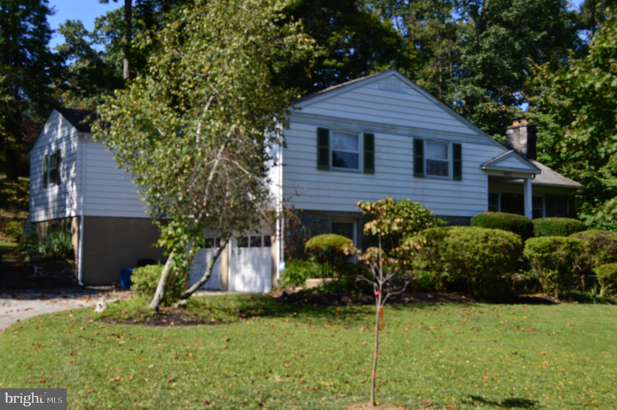 Nestled in a serene setting, this charming stone split-level Colonial home offers a perfect blend of comfort and style. Built in 1962, the property is ready for your special touches to restore its original splendor and beauty, providing ample space for relaxation or entertainment. With four spacious bedrooms, two full bathrooms, and a powder room, this home is designed for both functionality and warmth. Step inside to discover a welcoming interior adorned with hardwood flooring. The heart of the house is the eat-in kitchen, ready for a remodel and renovation to make it your special cooking sanctuary. The breakfast area is perfect for casual dining. The lower level offers a spacious den, and the second lower level has a finished space with a wet/dry bar & second fireplace for entertaining guests. Cozy up in the living room by the wood-burning fireplace, a perfect spot for chilly evenings. The second floor offers four spacious bedrooms and two full baths. One in the primary bedroom and a large hall bath. The thoughtful layout includes an attic for additional storage, making organization a breeze.
Outside, the property boasts a generous 0.74-acre lot that backs to trees, providing a tranquil backdrop for outdoor activities. The partly wooded landscape is beautifully landscaped, offering a peaceful escape right in your backyard. Enjoy the convenience of an attached garage with space for two vehicles, along with additional driveway parking. Located in a friendly neighborhood, this home is just a short drive from local amenities, including shopping, dining, and recreational parks. The community offers a variety of options for outdoor enthusiasts. With its inviting features and prime location, it's ready to welcome you home. Don't miss the opportunity to make this delightful residence your own!