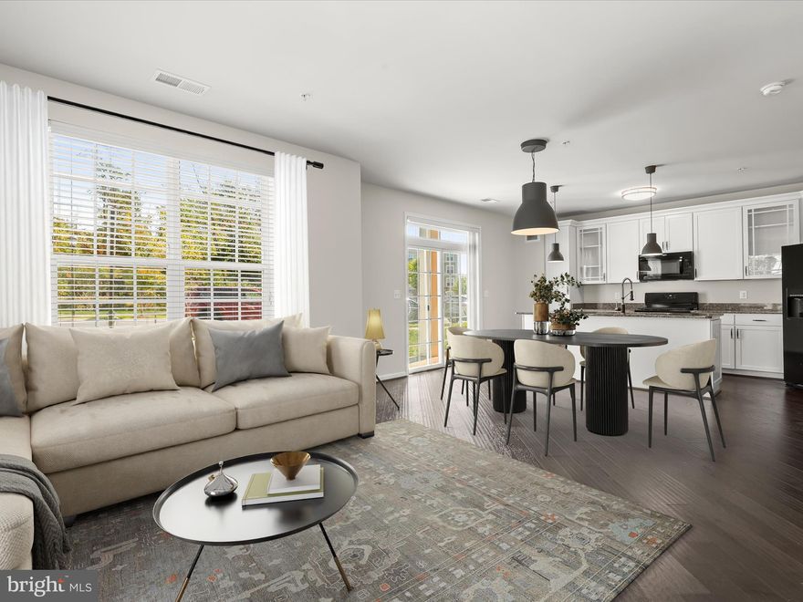 Welcome to 3825 Doc Berlin Drive #17, a beautifully designed two-bedroom Corner-Unit condo perfectly situated off of Norbeck Road & MD-97 offering fast access to Rockville & ICC (MD-200). This thoughtfully appointed home blends modern comfort with timeless appeal, creating a retreat that is both stylish and convenient. Inside, an open floor plan unfolds with gleaming engineered wood flooring that flows throughout the main living spaces. The kitchen is as functional as it is elegant, featuring crisp white cabinetry with roll-out drawers, gleaming granite countertops, and sleek black appliances that create a striking contrast. An inviting island with a breakfast bar provides the perfect spot for morning coffee or casual dining, while the sliding glass door topped by a transom window fills the space with natural light and opens to a patio for fresh air and relaxation. The kitchen seamlessly connects to a dining area and a spacious living room, where windows on two sides create a bright, airy atmosphere ideal for entertaining or quiet evenings at home.
The primary suite offers a peaceful escape, complete with a large walk-in closet and a private bath showcasing a tiled shower. Across the entry hallway, the second bedroom offers added privacy and convenient access to a second full bath, making it perfect for guests or a home office.
Additional highlights include your own front-loading washer and dryer tucked neatly into a utility room for easy laundry days, as well as ample storage throughout the unit. Outside your door, the community enhances your lifestyle with plentiful unassigned parking, walking trails, picnic areas, and a playground inviting you to enjoy the outdoors without the upkeep of a single-family home. With its prime location, upscale finishes, and effortless layout, this condo offers the perfect balance of comfort, convenience, and low-maintenance luxury.