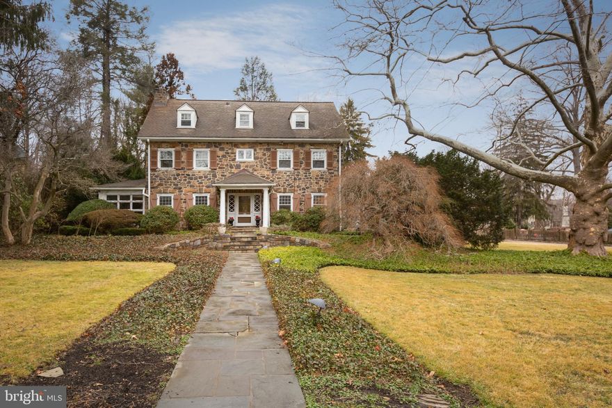 Professional Interior Photos Coming Soon! The location of this classic stone colonial in Wayne is unbeatable. Walkable to both downtown Wayne and the train station, it is situated on nearly a full acre, and surrounded by multimillion-dollar homes. With timeless touches, including crown molding, French doors, and a pretty fireplace, the home is well built and enduring. Its location, within the excellent Radnor School District and close to all major thoroughfares and the towns of Wayne and St Davids, couples warmth and beauty with an ideal setting. Also notable is the sheer amount of outdoor space, unusual for this neighborhood. A beautiful, expansive lawn and walkway lead to the front entrance and wide front door. The welcoming foyer has parquet flooring, and leads to the formal living room, with its custom millwork, deep-silled windows, and white-mantel fireplace, flanked by two doors leading to the enclosed, heated porch. With brick flooring and an exposed stone wall, the porch has a skylight and numerous windows to let in plenty of sunlight. French doors lead from the center foyer into the elegant dining room, also with beautiful crown molding and a chandelier. There is also a family room between the dining room and kitchen. The home’s kitchen is bright and cheerful, with a center island with cooktop, plenty of white cabinetry, and tiled floor and backsplash. The kitchen also has a double oven and additional open shelving. There is also space for a nice breakfast nook in the kitchen, as well as a powder room. A door leads to the large and level outside yard, with its open patio and lovely views. From the center hall, a pretty staircase leads to the second level: with four bedrooms and two full baths, this level has plenty of room. Wonderful built-in cabinets flank the center bath, which has a tub/shower combination and large, double-sink vanity. Each of the bedrooms has windows and closets, and three of the four are carpeted. Toward the back of the home, the fourth bedroom has hardwood floors, and the adjacent bath also has a tub/shower combination. There is a laundry closet here, as well as shelving outside the bath. The staircase leads up to the third level, with three additional bedrooms and a hall bath with tub. The rear yard is expansive and perfect for entertaining through the seasons. With its proximity to so much, including regional rail stations at both Wayne and St Davids, green spaces such as the Radnor Trail, and a wide variety of shopping and restaurants, this home has timeless appeal.