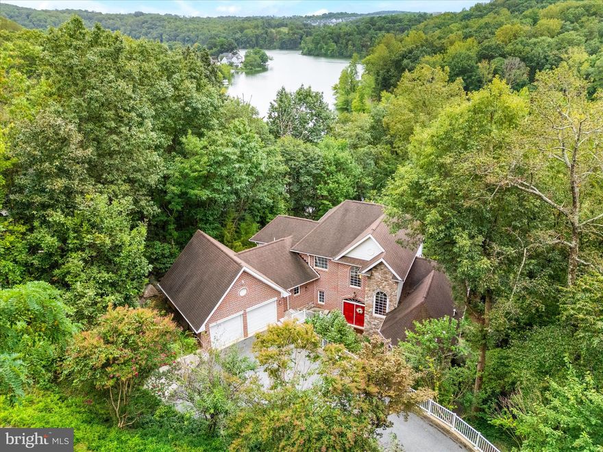 Welcome to luxury lakeside living at its finest in beautiful Lake Linganore! This home has TRUE LAKEFRONT access with it's own stone cut staircase down to the water, where you can step onto your own private dock and enjoy spectacular lake sunsets!  This newly painted stunning 6-bedroom, 5-bathroom home invites you into a world of elegance and comfort from the moment you enter its grand entrance. As you enter, you're greeted by a spacious open foyer featuring gleaming hardwood floors that flow seamlessly throughout the main level. The expansive floor plan features beautiful picture windows, bathing the interior in natural light and offering breathtaking views of the lake. Cozy up on winter nights by the large stone mantel fireplace in the living room, or entertain guests in the gorgeous chef's kitchen featuring a large wrap around island, ample cabinet storage, and upgraded appliances while overlooking the dining area—an ideal setting for hosting dinner parties or more casual family gathering. Relax in the inviting sitting room while taking in the serene lake views, or enjoy your morning coffee in the charming breakfast room. Retreat to the main level primary suite - a true sanctuary featuring a fully remodeled spa-like bathroom with a luxurious soaking tub, double vanity and expansive shower. Upstairs, three beautifully appointed bedrooms await, offering unparalleled views and comfort for family or guests. There are also two full bathrooms upstairs for your comfort. The lower level presents endless possibilities, with a den perfect for a game room, workout space or play area. Additionally, discover an in-law suite boasting two bedrooms, a full bath, and a separate kitchen area—ideal for accommodating guests. Outside, the entertainment options continue with a two-tier deck for summer barbecues with newly replaced deck railings, a sailing shade, and a dedicated firepit overlooking the lake—perfect for gathering with loved ones and enjoying the tranquil surroundings. A newly black iron fenced yard is a recent addition. Stroll down to your private dock to relax with a book, take a refreshing dip in the lake, or embark on a boating adventure. The natural stone staircase is gently lit at night and forms a beautiful architectural accent to the spectacular Aspen neighborhood. Residents of this community enjoy access to a wealth of amenities, including running trails, pools, tennis courts, sandy beachs, a summer concert series, food truck nights, hiking trails, and more. Plus, with its convenient location just minutes from downtown New Market and the award-winning attractions of Frederick, every convenience is within reach. Live your bliss!