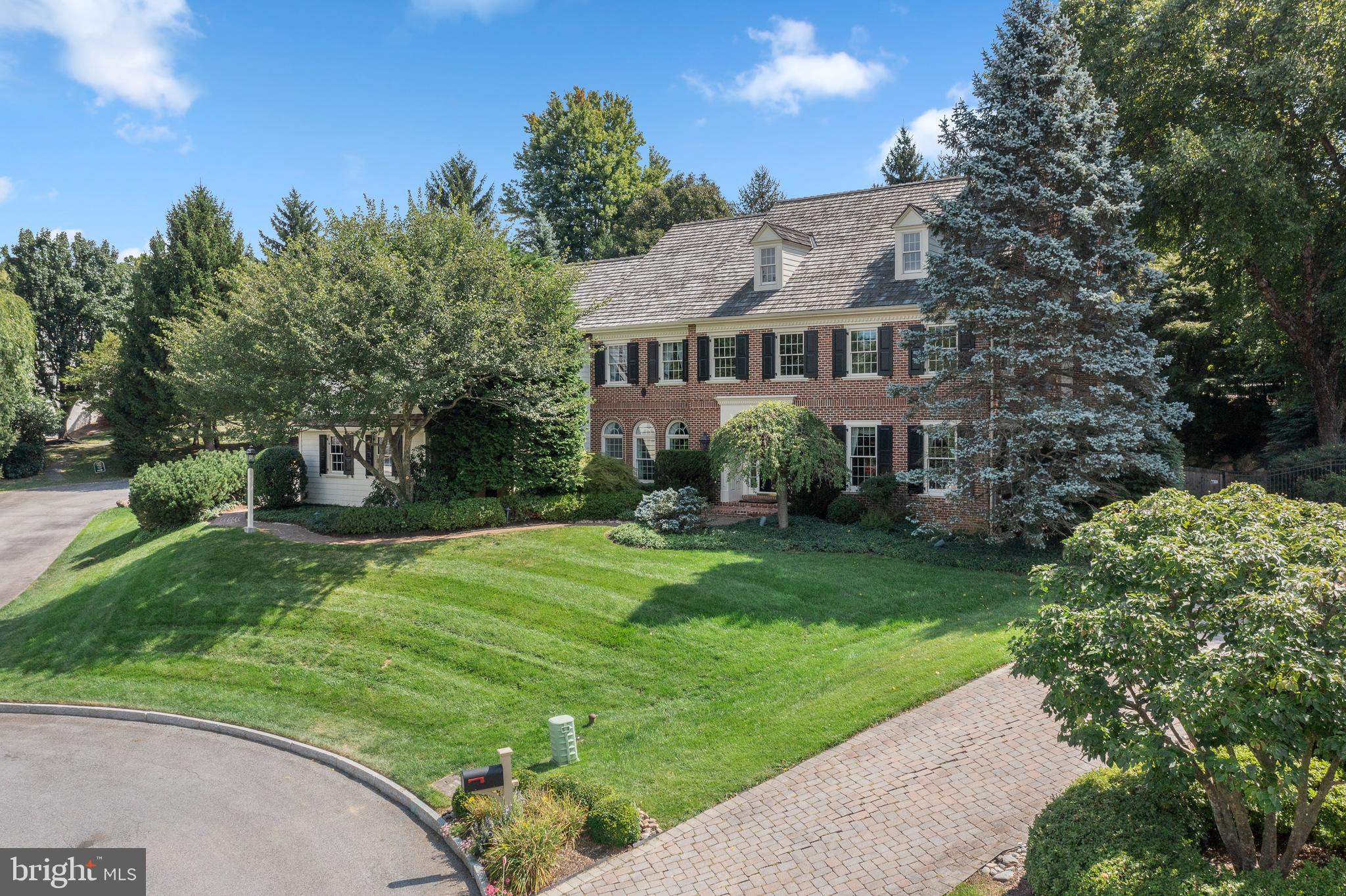 Fabulous Vaughn-built, extremely well maintained 4 bedroom home, with a bonus lower level 5th bedroom or office and 3 car garage. This home has only had one owner, and sits on a quiet cul de sac in Radnor Township with a pool and elevated hot tub/spa with waterfall! This home sits beautifully on the street, and you will be immediately wowed by the exterior features. It features brick and siding, a cedar shake roof and dramatic statement windows. Over 6,000 square feet of living space and a beautiful pool with spa, situated in the Radnor school district of Bryn Mawr, make this home incredibly desirable. This location offers many conveniences…..Close to shopping and restaurants in the center of Bryn Mawr and Wayne, also Ardmore for Suburban square, easy ride to the Philadelphia airport and only minutes to Ardmore station with Amtrack service to NYC.
The brick walkway leads you to the gracious, two story entry foyer with a dramatic staircase. The entire main level has pristine hardwood floors, (the family room has cozy carpet) and attractive moldings. To the right is the formal living room with fireplace, and a formal powder room straight through the foyer. To the left is the formal dining room with butler’s pantry and wet bar, leading to the sun filled kitchen, with sub zero refrigerator and breakfast room, renovated in 2010, and featuring high ceilings and white cabinetry. Off of the kitchen is the trex deck leading to the inground pool with spa/hot tub, which makes for easy indoor/outdoor living. Directly next to the kitchen is the open concept family room with fireplace, also with high ceilings and big pretty windows. Next to the family room is the office/den with fireplace and built-in shelving and millwork, making work from home easy in this beautiful setting. Also off of the kitchen is the family foyer or mudroom with an informal powder room, laundry room, big coat closet, back stairs to the bedrooms and entry to the 3 car garage.
Upstairs you will find the sprawling main bedroom suite, with room for seating as well and sleeping quarters. Large main bath with double vanities and soaking tub in addition to shower, and 2 large walk in closets. Also upstairs 3 additional beds and 2 more full baths. Finished lower level with full bath and bonus extra office or 5th bedroom, whatever you desire. Lower level also has large areas that are perfect for a gym or pool table, as well as a family room.