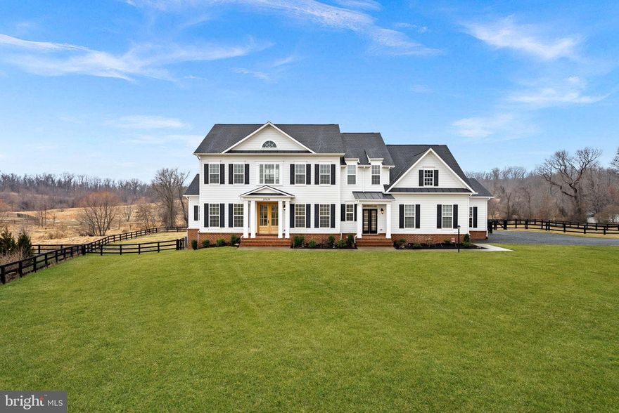 Set on 16 breathtaking conservancy acres in Purcellville,  this exceptional home offers timeless architecture, refined interiors, and the peaceful lifestyle Western Loudoun is known for. With HOA approval for horses and surrounding protected land, the property offers rare privacy, open space, and scenic pastoral views.

A long private drive leads to the stately white colonial, where a welcoming front porch and sweeping countryside vistas create striking curb appeal. Built by renowned Carrington Homes, the Kendall Lane model is celebrated for its craftsmanship, elegant design, and thoughtfully designed living spaces.

Inside, a gracious foyer welcomes you with rich hardwood floors, detailed trim work, and a beautifully crafted staircase. Arched openings, elegant moldings, and beautiful solid wood French doors that frame views of the surrounding landscape add warmth and architectural character throughout the home, while expansive living areas create an effortless flow between spaces.

At the heart of the home is a stunning chef’s kitchen designed for both entertaining and daily life. Featuring expansive quartzite countertops, custom white cabinetry, double wall ovens, a statement range hood, and an oversized center island with seating, the kitchen opens seamlessly to the family room and sun-filled morning room where walls of windows frame tranquil views of the surrounding acreage.

The family room is a true showpiece, featuring an elegant coffered ceiling, a beautiful fireplace that anchors the space, and large windows that fill the room with natural light. 

A main-level bedroom with a full en suite bath provides the perfect space for guests, extended family, or a private home office.

Upstairs, the luxurious primary suite offers a true retreat, complete with a tray ceiling, hardwood floors, and a spacious sitting area highlighted by an elegant arched window overlooking the property. The spa-inspired primary bath features dual vanities, a freestanding soaking tub centered beneath an arched window, and a large walk-in shower with elegant tile surround.

The finished lower level provides additional space for recreation, entertaining, fitness, or media. 

This remarkable property offers the rare combination of luxury living, protected land, and countryside charm—just minutes from Purcellville’s charming downtown, wineries, breweries, and farm markets.