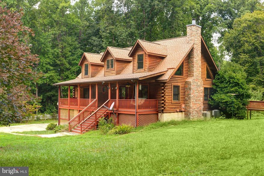 A beautiful custom built, waterfront log home. Wide open floor plan with soaring, beamed ceiling and stone fireplace. Main level master bedroom covered front porch & expansive deck. 100' of sandy shoreline, covered dock with lift, boat ramp and large on-shore sun deck & gazebo in quiet cove. Large wooded lot.  The kids will adore this! Come and see it today.