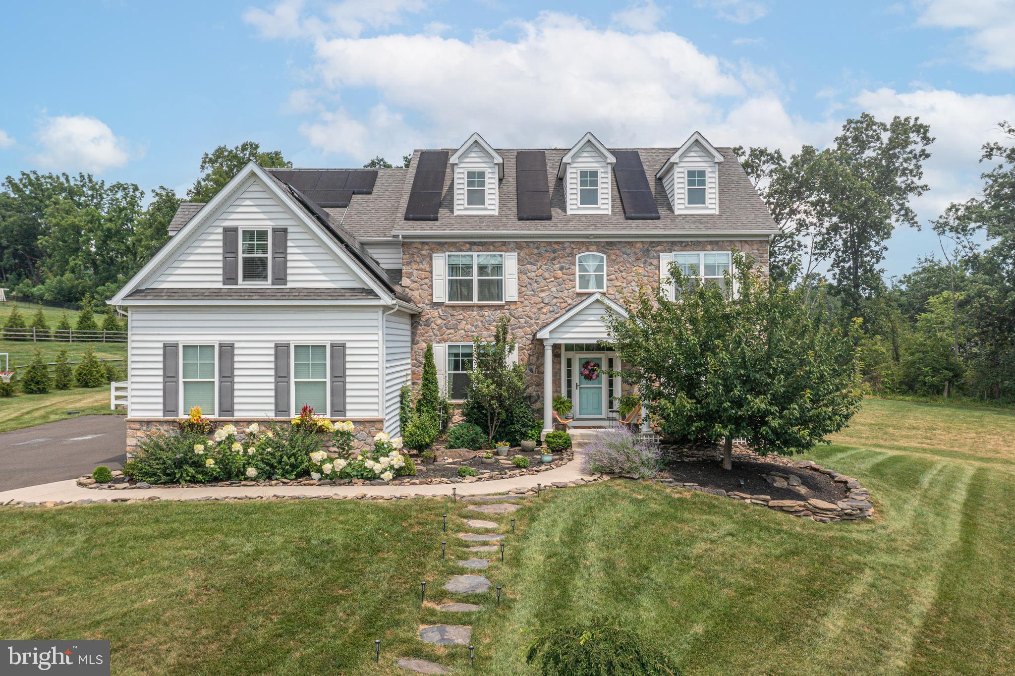 Located just north of Doylestown in the exclusive Owls Nest Farm community, this 3,726 sq. ft. home offers the perfect blend of modern design and classic stone-front charm. Set on over an acre of land, the property’s airy, open feel extends throughout the light-filled interiors. Inside, the foyer welcomes you with a grand staircase and soaring 9' ceilings. The main level features a home office, mudroom with custom drop zone, and a spacious family room with built-in bookshelves and a custom fireplace. The chef-inspired kitchen boasts a designer Lacanche Cluny french range, gold-tone accents, white quartz countertops, and a walk-in pantry. The layout is perfect for both entertaining and daily living, with a seamless flow into the dining and living areas. The main level also includes a private in-law suite with a sitting room, bedroom, and full bath. Upstairs, the main suite provides a serene retreat with an adjoining sitting room and a luxurious en-suite bath with a freestanding tub. The second bedroom has its own full bath, while the third bedroom features a unique layout with a walk-through closet and access to a fourth hall bath. Additional highlights include a large laundry room, finished basement with over 1,000 sq. ft. of potential space, and a fenced outdoor area with a pergola and raised cedar beds. Ideal for pets, play, or simply enjoying the outdoors, the expansive yard offers endless possibilities. Dual hot water heaters and a whole-home water filtration system enhance convenience. With sought-after Central Bucks schools and proximity to major routes, this home is a must-see for families seeking space, style, and flexibility.