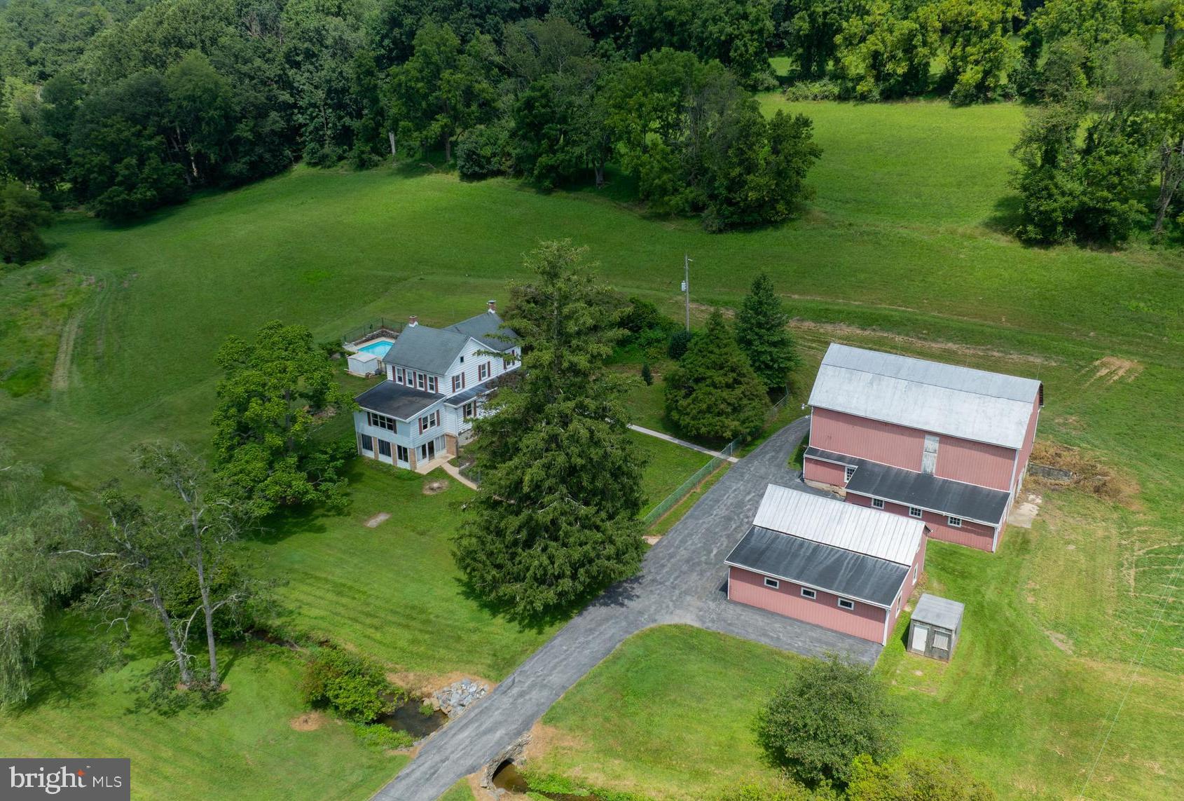 Prime location in Dallastown School District. Close to the PA/MD line and Nixon Park with 16,000 acres of parkland consisting of 12 miles of trails for biking, horseback riding & hiking along with a 220 acre lake for fishing & boating. Just steps away from the Hollow Creek Trailway that leads you into winding woods of Nixon Park. All of this could be yours! 30 private acres, a farmhouse with an inground swimming pool, detached garage, 2-story barn, and a peaceful stream running through your property. The interior features a kitchen and dining area, living room with a wood burning fireplace, 1st floor office, and a sun room that overlooks the stream in the front lawn. The upper level features 4 bedrooms and a full bath. The lower level offers a full basement and an enclosed patio. Additional possibilities with residential open space zoning. Easy commute to I-83 and Rt. 30. Close to restaurants, shopping, and local amenities.