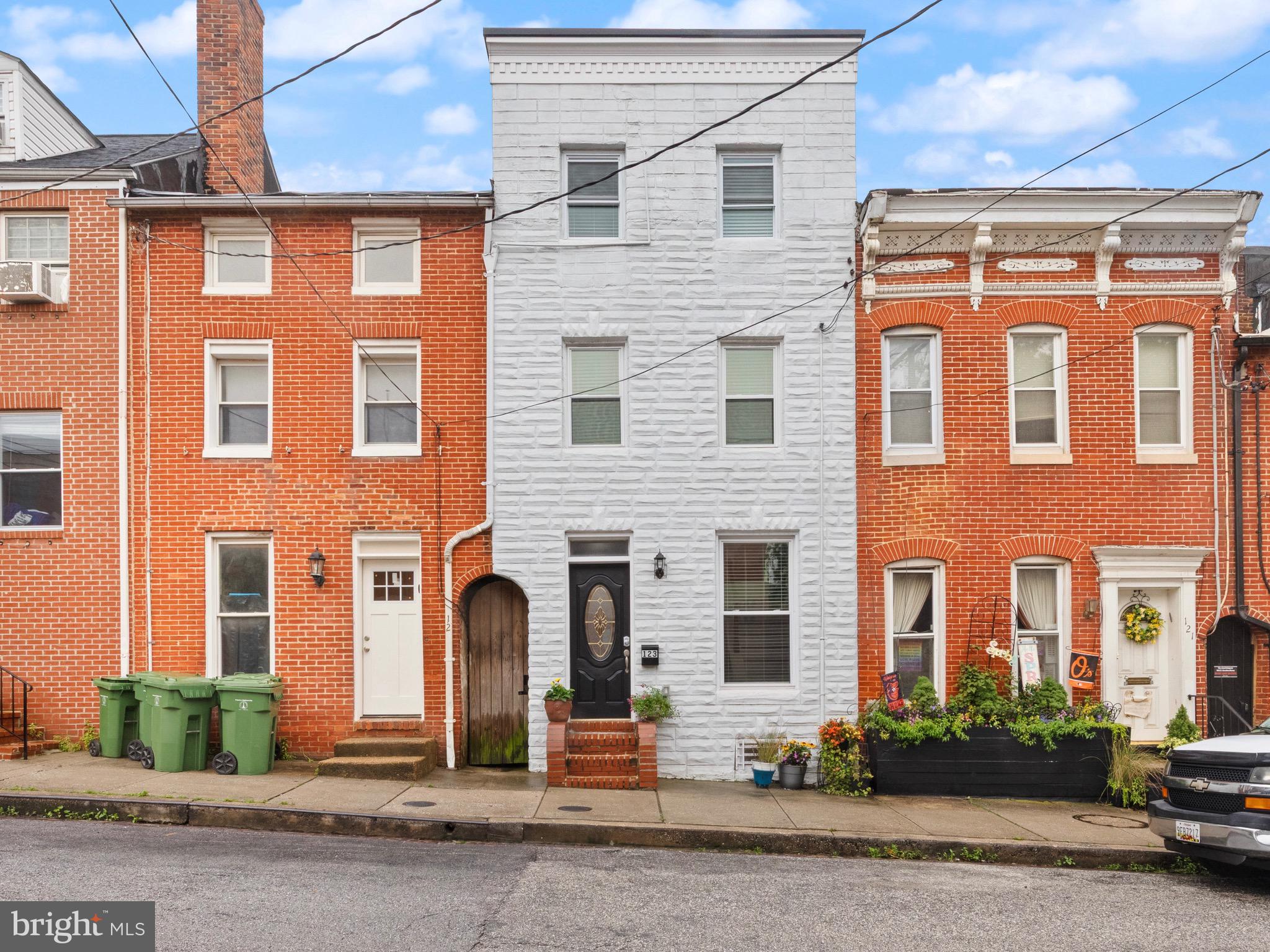 Welcome to 123 E Cross Street – A Rare, Renovated Federal Hill Gem! Tucked just one block from Cross Street Market and surrounded by urban convenience, this beautifully renovated 4-level row-home offers over 1,800 square feet of stylish and functional living space. With 4 bedrooms, 2 full baths, and 2 half baths, there’s room for everyone to spread out and enjoy. Completely gutted and renovated from top to bottom in 2023, this home features all new systems, plumbing, roofing, electrical fixtures, and finishes (all permits pulled through city)—truly move-in ready and designed for worry-free living. The main level features warm exposed brick, a convenient half bath, and a galley-style kitchen that leads to a fully fenced, oversized private patio—perfect for entertaining or relaxing under the tall trees that provide both shade and privacy. Bonus: The secure lot behind the home means no rear neighbors and added peace of mind for storing bikes or other personal items. Upstairs on the second level, you’ll find a primary suite with a walk-in closet, a charming ornate brick fireplace, and an updated ensuite bathroom with a double vanity and tile shower. A second bedroom on this level is perfect for a home office, nursery, or guest space.
The third level offers two additional generously sized bedrooms and another full bathroom. Each top-floor bedroom includes its own ductless mini-split HVAC unit, giving you personalized climate control and excellent energy efficiency. The fully finished basement provides a flexible space ideal for a hobby room, home office, or guest accommodations. This level also includes a utility/storage room with a slop sink and stacked washer/dryer—a thoughtful and practical setup for modern living.
Enjoy the perks of city living with a twist: green space across the street at the school is a great spot for pets or play, and non-permit parking on the school side ensures easy guest or long-term parking. Plus, a small school parking lot offers convenience for unloading groceries or large items. Technically the dumpster is for school use only ;) Use as a stand-alone investment property with an estimated $3200-$3400 month rental income or live in one bedroom as an owner occupant and rent the other bedrooms to cover your mortgage!
Don't miss this opportunity to own a turn-key home in the heart of Federal Hill—convenient to shopping, dining, parks, and more!