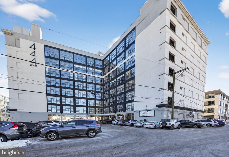 Experience elevated urban living in this impeccably designed residence at the newly reimagined 444 Lofts, perfectly positioned where the sophistication of Old City meets the energy of Northern Liberties. Unit 407 is a rare offering—an expansive, architecturally rich 1‑bedroom loft showcasing dramatic industrial character blended with refined contemporary finishes. Flooded with natural light from walls of oversized, South/East‑facing windows, this residence offers sweeping views of center city and  Old City that create an unforgettable backdrop day and night. Authentic warehouse‑conversion elements—including exposed brick, concrete beamed ceilings, and open volumes of space—combine effortlessly with modern luxuries to deliver a truly elevated living environment. The custom kitchen is a center‑piece of the home, appointed with granite countertops, a large island with exceptional cabinet storage, stainless steel appliances, and a dedicated wine chiller—perfect for entertaining or savoring a chilled bottle upon move‑in. The generous living and dining areas offer the scale and airiness that discerning buyers seek. Retreat to a spacious primary suite framed by two grand windows with panoramic views. The spa‑inspired bathroom features dual vanities, elegant tilework, designer fixtures, and a serene sense of boutique‑hotel luxury.
Additional highlights include hardwood flooring throughout, exceptional closet storage, in‑unit laundry, and one premium parking space in the building’s secure gated lot—an invaluable convenience in this coveted neighborhood. Residents of 444 Lofts are welcomed through a stunning lobby and exterior renovation, elevating the building’s presence to a contemporary showpiece. Amenities include an expansive 8,000 sq ft fitness center, 24/7 front desk personnel, and dedicated on‑site maintenance—delivering a level of service and lifestyle rarely found at this price point. With unmatched character, breathtaking views, premium upgrades, and access to Philadelphia’s most celebrated dining, galleries, boutiques, and the waterfront, Unit 407 offers an exceptional opportunity to own a truly distinctive luxury loft residence. A must‑see for buyers seeking space, style, and standout design.