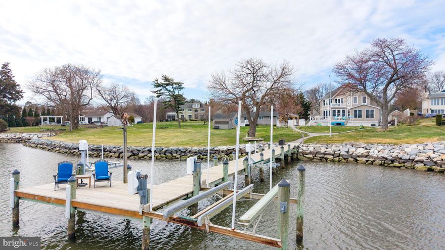 Live every day like vacation in this STUNNING waterfront private oasis just minutes from the Bay Bridge, where coastal luxury meets effortless Chesapeake Bay living. Nearly 3100 sf, , this gorgeous retreat features four spacious bedrooms and three beautifully updated baths, designed for comfort, style & unforgettable gatherings. Main level bedroom & full bath offer flexibility! The heart of the home? A magazine-worthy coastal kitchen with new custom cabinetry, gleaming white quartz countertops, & shiny stainless steel appliances. Wide-plank white oak flooring that carries warmth and sophistication. Open, airy, and filled with natural light — every space feels intentional and elevated. Primary suite emulates the  finest of hotels with cozy gas fireplace, catwalk to waterfront balcony, bonus room/office & STUNNING  spa bath with sunken tub, walk-in-shower & vanity for two, heated floors & spacious closet for ample storage. Step outside to your own resort setting — with private in-ground pool, expansive entertaining areas, maintenance-free deck with cable rails for nautical feel. and a private pier with boat lift & two jet ski lifts - just three lots from direct Chesapeake Bay access. With 4' MLW, boating enthusiasts will appreciate effortless access to open water in minutes. This is more than a home — it’s a lifestyle, waterfront living re-defined.  Opportunities like this don't float by twice- your boat belongs here!