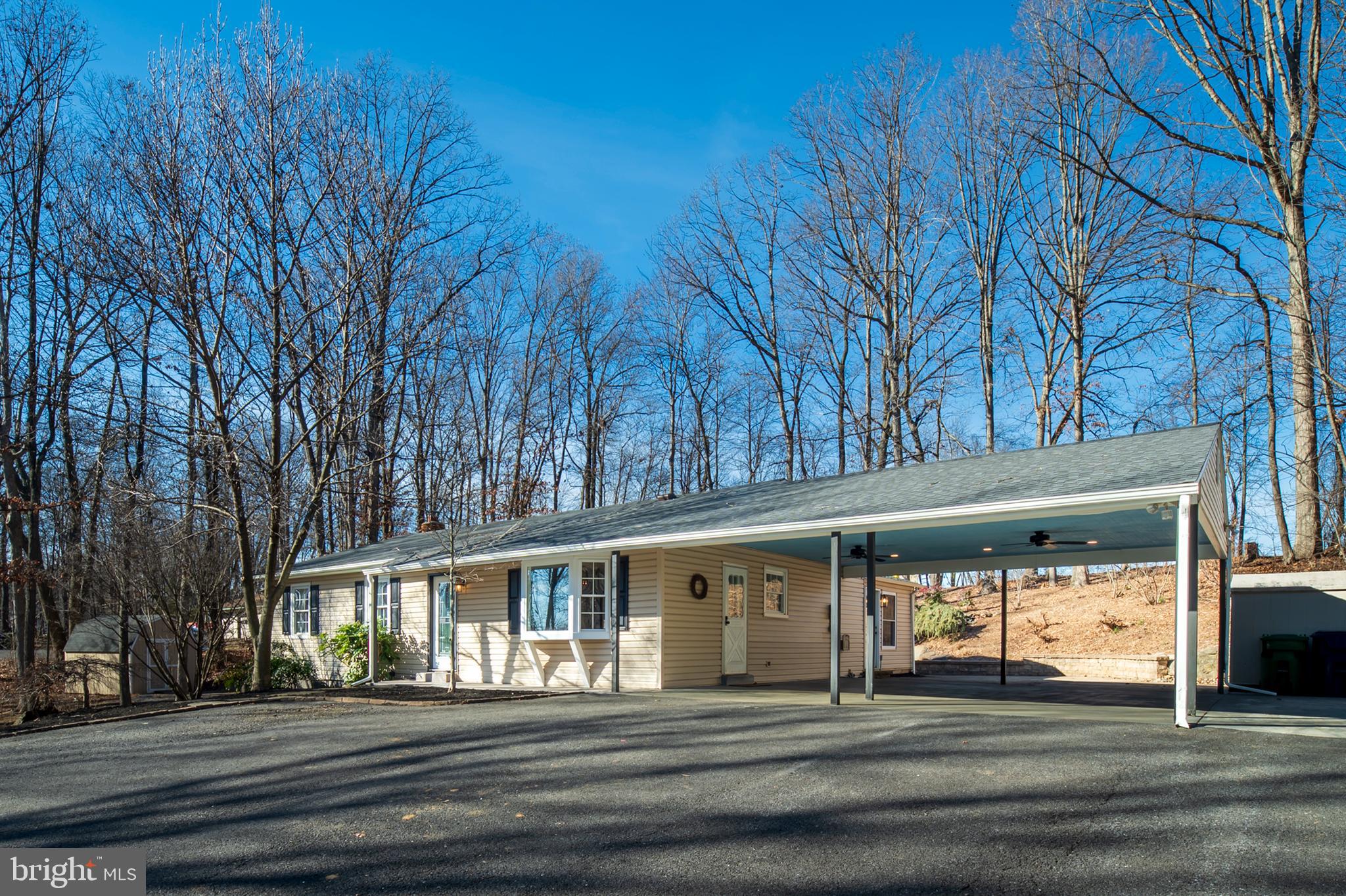 Gorgeous, renovated rancher on a wooded lot with a large 2 car carport, extensive multi-level stone patios including a large fire pit, pond with a waterfall and stone retaining walls. An updated kitchen with granite counters, stainless appliances, bar seating area (as well as a pantry) open to a large family room addition that overlooks the backyard and pond area. The main level offers hardwood floors through most of the main level, 3 bedrooms and 2 updated full baths (including 1 master suite). The fully finished basement has an updated full bath, storage room/guest room, wet bar with sink and granite counters, wood burning stove, walkout level to side patio and LVP flooring throughout. Situated on 1.34 acres with plenty of trees, backing to farmland, a playground area towards the back of the lot with additional flat play area and NO HOA. New roof in 2023 and a 1-year Cinch Home Warranty is included. Septic was pumped last spring and the well pump was replaced about 3 or 4 years ago. Country feel, yet minutes to downtown Mount Airy shopping, restaurants, wineries and more. Conveniently located near Frederick, Damascus, I-70, I-270, & accessible routes to Montgomery County, Baltimore & D.C