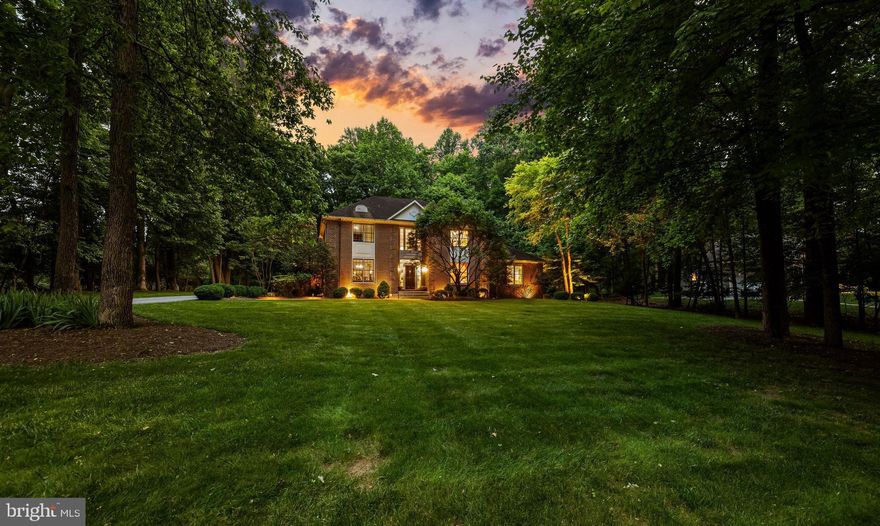 Welcome to this exquisite custom built Chestnut Woods home, where timeless craftsmanship meets modern comfort. Bathed in natural light, the interior highlights pristine hardwood floors, detailed millwork, and a seamless open floor plan designed for today’s lifestyle. The desirable main-level primary suite offers dual walk-in closets with custom organizers, a spa-inspired bath with jetted tub, and a frameless glass shower. Upstairs provides 4 ample sized bedrooms and a secondary staircase provides convenient access to the breakfast room and kitchen below. The chef’s kitchen features 42" solid wood cabinetry, a center island with breakfast bar, and a remarkable walk-in butler’s pantry offering unrivaled storage and prep space. The fully finished lower level is an entertainer’s dream, with areas for fitness, billiards, a wet bar, and a state-of-the-art home theater.  Outdoor living is equally appealing with a brick paver patio ideal for entertaining, all while enjoying the natural beauty that surrounds the home.