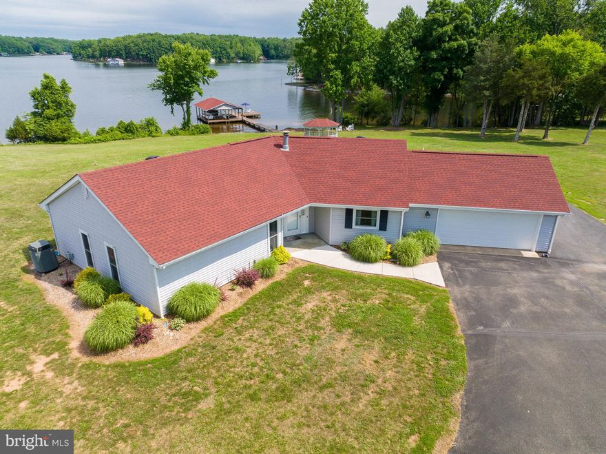Rare opportunity to own this beautiful Lake Anna waterfront retreat located on the public side of the lake with an additional lot included for added space, privacy or to build another home! Enjoy gorgeous unobstructed views on the sought after Southern end of the lake with no HOA's and 113ft of shoreline. You'll also enjoy mountain views from a distance. Covered boathouse has two slips with two electric lifts and a sun deck. Take a walk over to your own sandy beach and live like you're on vacation everyday.  It's easy to relax here in this 3 bedroom, 2 full bath retreat that has a lakeside family room with 3 sliding doors, vaulted ceilings and a gas fireplace. Separate living room with LVP flooring and a spacious kitchen that flows perfectly back into the family room. Enjoy BBQ's on the patio, drink your morning coffee in the gazebo or unwind in the hot tub that overlooks the lake. There is an attached oversized finished 2 car garage and also a huge detached 40x60x20 barn/garage that is perfect for storing your boat, RV, tailer or cars. There are 3 garage doors (a 14 ft, 13 ft and a 10 ft door) and an upstairs loft area/home office. The whole house generator also conveys. HVAC was replaced 8 years ago and the house, garage/barn and shed all have a new roof that was replaced 3 years ago. This home comes fully furnished, is move in ready and High-Speed Xfinity Comcast  internet is available here! Your lake oasis is waiting for you and the possibilities are endless here! Call today for more info and to schedule your showing.