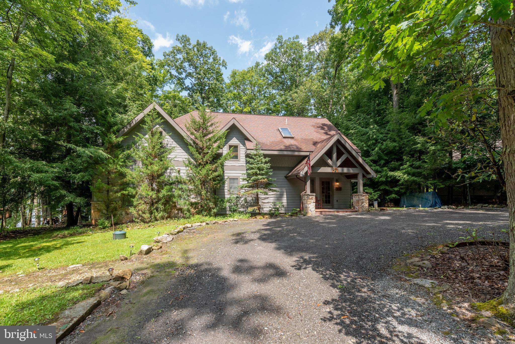 The sought after Lake Shore Drive Lakefront! This charming lakefront home has everything you would want in your Deep Creek Lake escape. The warmth of wood hugs you the minute you step in the door. The beautiful, spacious living room boasts a wood cathedral ceiling, a wall of glass and a stone fireplace sets off the room. A spacious loft overlooking the living room adds to the charm. The family room is off of the kitchen with another stone fireplace! The charming kitchen has a large eat at bar with granite countertops and room for more than one chef. Dining area is off of the kitchen/family room with windows across the back. The Primary Bedroom has a private bath with a large tiled shower. A second main level bedroom with a bath is located off of the family room. Upstairs are two charming, spacious bedrooms, and a full bath and a half bath that opens to the tub shower area. The deck area spans the home with a wonderful hot tub, hammock and firepit area. The lakefront is gorgeous with a recently expanded Type A dock! The views are nothing short of breathtaking! A second firepit area and canoe rack completes the picture! When you hear, "Location Location Location"....this is it! Located just minutes from the Ski slopes, movie theatre and shopping. Schedule your appointment and end your search!