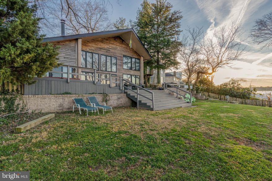 A FULLY furnished home with amazing Potomac River views from this riverfront home! Get in the water or just enjoy the view from the deck or the gourmet kitchen with quartz counters, a large island, stainless steel appliances, and a breakfast area that has direct access to the deck and hot tub. The spacious great room with its floor-to-ceiling windows, impressive river views and deck access makes entertaining a crowd easy and fun and inspires the best conversations you've had in months.
Two primary bedroom suites with king-size beds and two additional bedrooms also with king-size beds, along with full-sized bunk beds allows room for everyone. With your very own dock with a boat lift it's perfect to take a boat ride to National Harbor, Old Town Alexandria, The Wharf, and Navy Yard. Make this your home as you relax in this waterfront property equipped with kayaks, hot tub, fire pit, sunset deck, a pier, hammock, and a swing suspended from the clouds!
