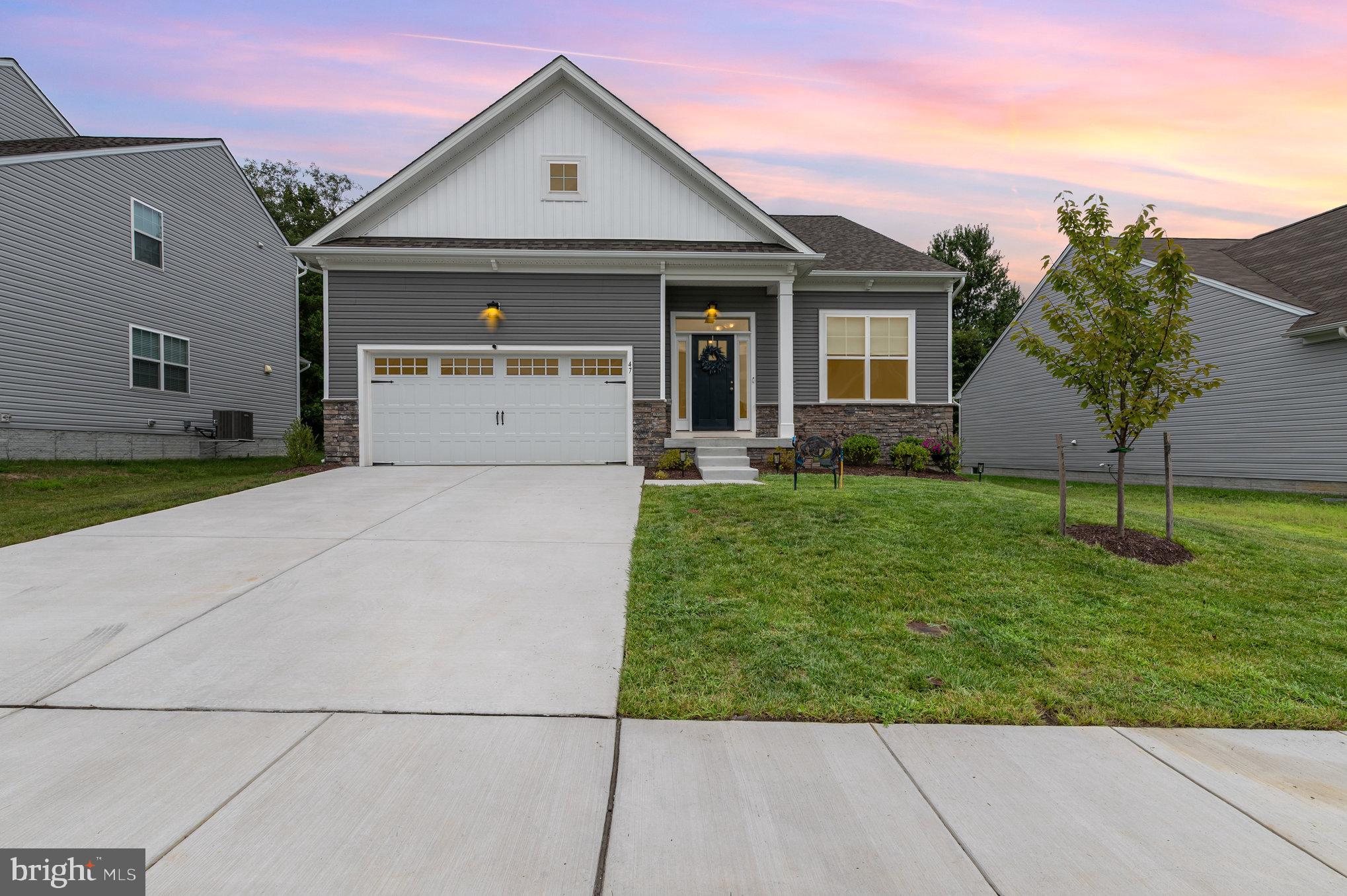 Why wait to build? This rare 1-year-old rancher in The Pines at Cherry Hill is move-in ready and packed with premium upgrades throughout.
Enjoy 9-foot ceilings, LVP flooring, upgraded soft-close cabinetry, quartz countertops with a stylish backsplash, stainless steel appliances, and a beautiful stone fireplace. A 4-foot extension on both the main and lower levels adds extra space and functionality.
The main level features 2 bedrooms, 2 full bathrooms, and a laundry room with cabinets. The primary suite includes an upgraded bath with high-end finishes. The finished lower level offers a huge 3rd bedroom, another full bath, and plenty of space for entertaining, guests, or hobbies.
Step outside to a composite deck and pavers at the bottom of the stairs—perfect for relaxing or entertaining. The finished garage includes shelving for convenient storage and an EV charging station.
Thoughtfully designed and better than new, this is a rare opportunity awaiting it's new owners!