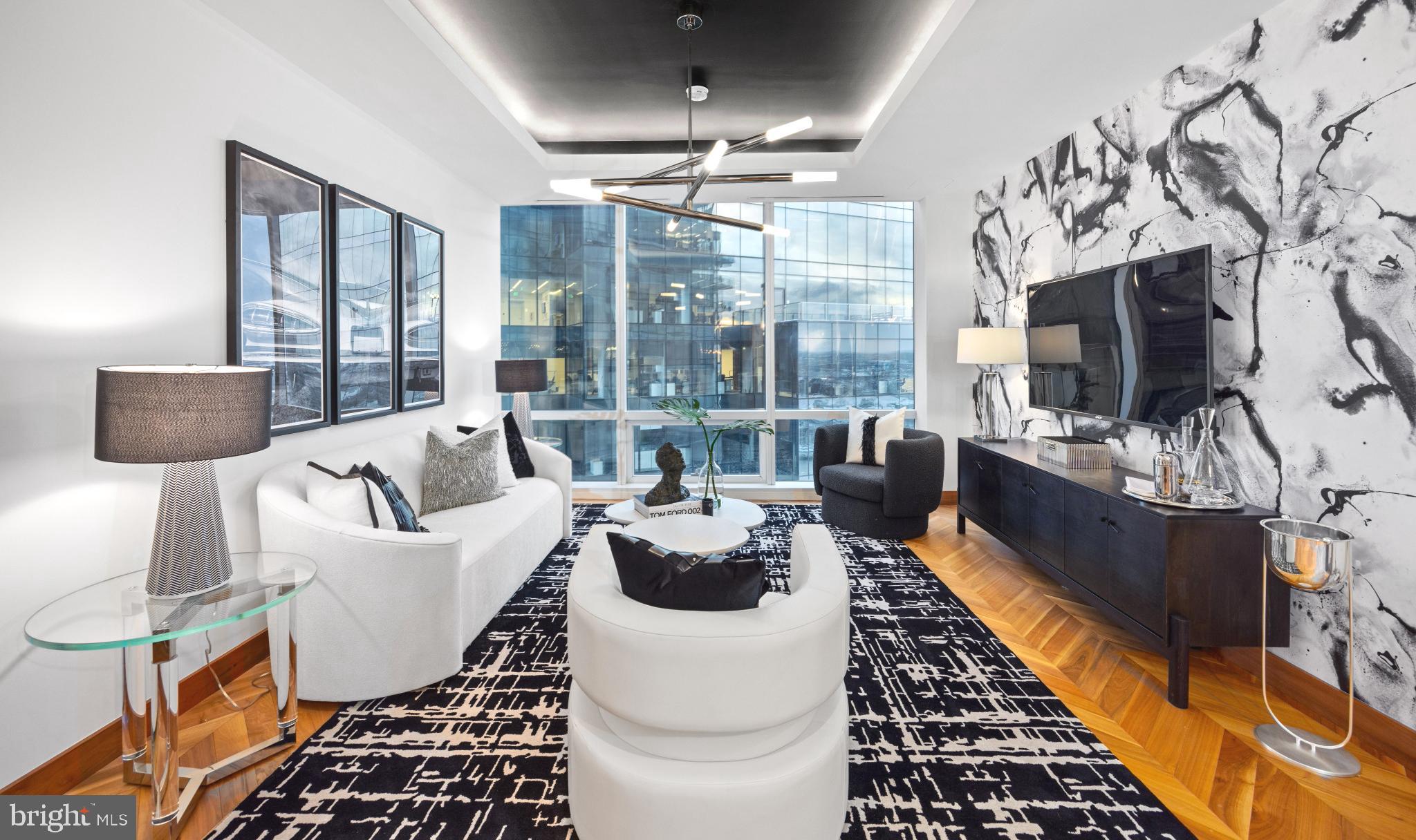 Discover luxury city living in this gorgeous 19th-floor home in the prestigious Four Seasons Private Residences. Located in Baltimore’s vibrant Harbor East neighborhood, this elegantly designed home features one-bedroom, one-and-a-half-baths, and a den, ideal for an office, work-out space or additional bedroom. A spacious open layout seamlessly connects the kitchen, dining, and living areas - perfect for both relaxation and entertaining. Soaring 10-foot ceilings and floor-to-ceiling windows flood the space with natural light, highlighting beautiful details such as walnut herringbone wood floors, designer lighting, and a chef-caliber gourmet kitchen outfitted with Miele appliances. The primary suite features a generous walk-in closet and a luxurious marble en suite bath complete with a dual vanity, and soaking tub. Every element is crafted to the highest standard, offering comfort and elegance in equal measure. Residents enjoy access to the legendary Four Seasons service and amenities, including a private indoor pool and spa, fitness center, restaurants, and meeting rooms, ensuring a luxury living experience in one of Baltimore’s most sought-after addresses. And of course, enjoy the city’s best waterfront dining, boutique shopping, cultural attractions, and recreational activities—right at your doorstep in Harbor East.