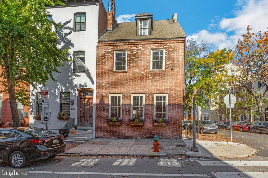 Welcome to 2401 Spruce Street!   This historically certified (circa 1832) corner, 3 bedroom/ 2 bathroom town home with One Car Parking is a glorious and newly renovated residence characterized by its meticulously maintained traditional architecture on the exterior and its contemporary finishes and clean modern aesthetic in the interior. The space flows naturally throughout the home and blends contemporary and traditional elements seamlessly.  The first floor features open concept living with a bright and spacious kitchen, dining area and living room with soaring ceiling height and three exposures (south, east and north) illuminating the entire space in great natural light.  The well-appointed chef’s kitchen features a quartz waterfall island, Poggenpohl cabinetry, professional grade Wolf and Sub-Zero stainless steel appliances including a six burner range and large oven, refrigerator, separate freezer drawers, second full-size oven plus a microwave/ convection oven. The generous dining space is ideal for large dinner parties and entertaining and flows into the spacious living room with three large windows and a beautiful stone clad gas fireplace.  The sculpture- like floating staircase leads to the primary bedroom en suite which features a wrap-around wall of windows and a stone clad fireplace.  Gorgeous custom built cabinetry flank the walls creating an elegant walk through dressing closet where you can lounge while preparing for a night out. A coffee station and desk/ vanity add to a sophisticated dressing room feel.  The luxurious bathroom features dual vanity sinks, a soaking tub, stone finishes and a glass enclosed spa shower plus a concealed laundry area.  The top floor features a second bedroom with exposed original beams, windows on three sides and a pretty skylight and wet bar including Sub-Zero refrigeration.  The amazing deck with built-in planters and lush flowers adjoins this bedroom and contributes to the stunning views of the Center City skyline just outside. The newly redesigned lower level is a multi-functional flex space to use as a third bedroom, work out space, home office or all three.  The full bathroom features a stall shower, Duravit fixtures and abundant closet space with large storage spaces throughout. The parking space is right outside your back door. Located in Albert Greenfield School Catchment. One block from Fitler Square and Schuylkill River Park and trail, the dog park, world class restaurants, boutiques and shopping, CHOP, University of Pennsylvania and public transportation.  A walk score of 94.  A must see!