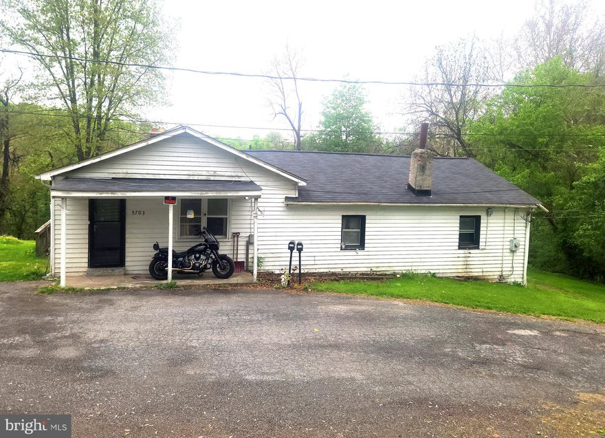Great price for a single family home with 1746 SF on the main level, and a partially finished basement, on 1.38 acres. NO city tax, private location, fast and easy access to 70/270/15. Main level has a spacious living room freshly painted, eat-in kitchen, 3 BR and a full bath. The rear part of the house was used as an in-law suite with a separate full (and big!) second kitchen and the 4th bedroom, and is open to the main part of the house. If you don’t need 2 kitchens, lose one and have a huge family room. MANY possibilities here. The walkout basement is partially finished, so there is a 3rd kitchen and a 2nd full bath - needs work.  Two fireplaces, beautiful view out the back of the yard and the trees and woods beyond. TONS of parking, double detached garage with a recently added on storage shed/workroom. ROOF is 3 years old, WATER HEATER is new (2025), WELL PUMP is 2 years old and has a lifetime warranty, SEPTIC was pumped and inspected in 2024. This home is a diamond in the rough, needs work (mostly exterior trim, some parging, some fascia), but ready to roll - just move right in and make it your own.  Likely it won’t go FHA or VA due to exterior work needed. Your chance to get a single family home on  land for less then the price of a townhome or condo. Photos coming soon.  Open House May 2nd, 12 -3.