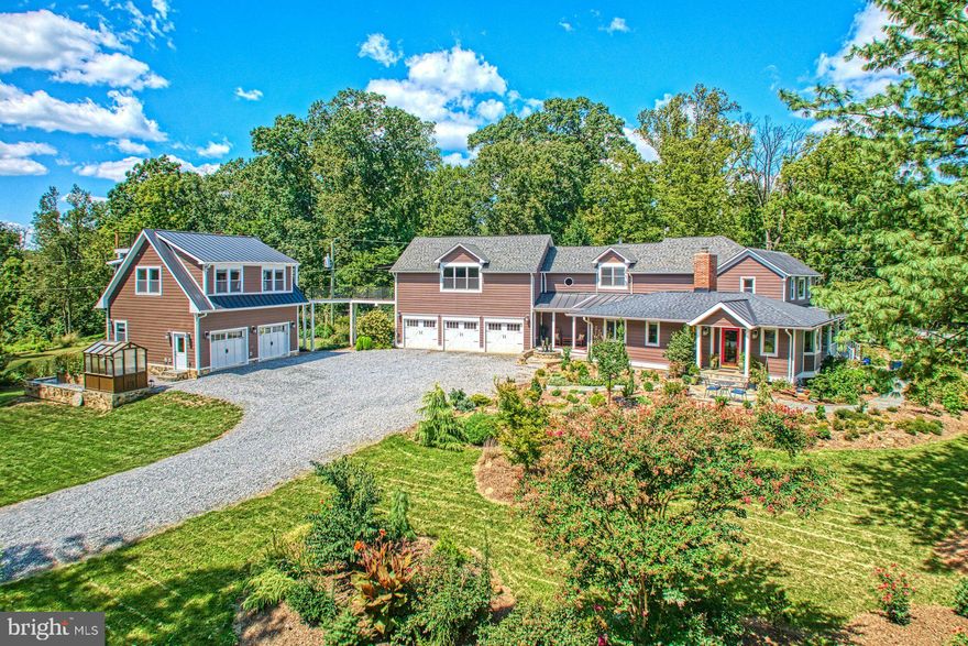 Step into a home where history and modern luxury coexist in perfect harmony. Originally built in 1890 and thoughtfully expanded and renovated, this residence offers over 4,100 sq. ft. of exquisitely designed living space with an oversized 3-car garage. The gated entrance, mountain views, and mature landscaping create a sanctuary of privacy and elegance. Inside, craftsmanship shines at every turn. Rich hardwood floors flow throughout both levels, complemented by custom cabinetry and elegant wainscot detailing. The chef’s kitchen is the centerpiece, boasting a bespoke walnut island with prep sink, two-drawer refrigerator, and abundant storage—ideal for gourmet cooking or effortless entertaining. Gather in the inviting living room, warmed by a wood-burning stove, the cozy family room and anchored by a charming fireplace, or host guests in the spacious main-level bedroom with its own full bath—perfect for multigenerational living, an au-pair, or weekend visitors. Upstairs, the primary suite is a retreat unto itself—generous in scale and impeccably appointed—accompanied by two additional bedrooms with custom built-ins and a versatile bonus room that easily adapts as a home office, studio, or den. Each bathroom is a work of art, designed with timeless finishes worthy of the pages of a luxury design magazine. Beyond the interiors, the estate offers layers of beauty and sophistication. The fully fenced property unfolds with Frank Lloyd Wright–inspired gardens, designed with evergreens and blooming perennials that create year-round visual harmony. A newly constructed detached carriage house provides a flexible studio space—perfect for guests, creative pursuits, or multigenerational living—connected to the main residence by a dramatic catwalk that marries modern design with historic charm. Outdoor living is where this home truly shines. Two porches invite you to relax and take in panoramic Sugarloaf Mountain views. The dining room and kitchen open seamlessly to beautifully designed patios, perfect for alfresco gatherings. A custom stone fireplace with gas starter, soothing water feature, and subtle exterior lighting set the stage for unforgettable evenings under the stars. The three-acre grounds are as functional as they are enchanting, with expansive lawns offering endless possibilities for recreation and entertaining. All this, just minutes from historic downtown Leesburg, Ida Lee, Morven Park, and Loudoun’s celebrated wineries, restaurants, and boutiques. With easy access to Rt. 7, the Dulles Greenway, and Dulles Airport, your private retreat is never far from convenience