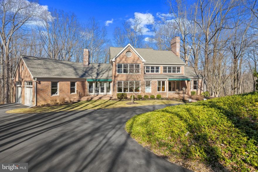 A long private driveway winds through lush woodlands, leading to this stunning Colonial estate nestled on over seven secluded acres along the meandering Middle Patuxent River in Triadelphia Woods. The property offers a harmonious blend of dense forests, open green space, and private shoreline trails. With extensive updates in the past two years, the home showcases eclectic, high-end design choices, expert craftsmanship, and an abundance of natural light streaming through expansive windows.

Step into the inviting foyer, complete with a convenient powder room for guests, or enter directly into the elegant living room, where a wood-burning fireplace sets a warm tone. This inviting space flows effortlessly into a screened porch, perfect for enjoying the serene surroundings. Hardwood floors extend into a private study, complete with a wood-burning fireplace, charming arched windows, built-ins, and direct access to a secluded balcony—a quiet retreat for work or relaxation. The chef’s kitchen is a true masterpiece, featuring stainless steel appliances, a large center island, sleek quartz countertops, a double sink, recessed lighting, a floor-to-ceiling subway tile backsplash, and a pass-through window to the sunlit breakfast room with elegant chair rail detailing. The formal dining room exudes timeless charm with a classic chandelier, corner built-ins, wainscoting details, and an abundance of natural light. The grand family room is nothing short of breathtaking, boasting cathedral ceilings, a striking two-story Zach Stone® fireplace, custom built-ins, and expansive front-to-back wooded views. A laundry room completes the main level for ultimate convenience.

Upstairs, three spacious bedrooms feature cathedral or vaulted ceilings, adding to the home’s grandeur. The luxurious owner’s suite is a private sanctuary, complete with three walk-in closets and a spa-inspired ensuite featuring dual vanities and a soaking tub. The additional bedrooms each offer walk-in closets and share a dual-access bath with double sinks.

The expansive lower level offers remarkable versatility with a spacious recreation room featuring gleaming hardwood floors, a wood-burning fireplace, elegant wainscoting, a half bath, wine cellar, walk-out exterior access, and a well-appointed wet bar, creating the perfect setting for entertaining. Additionally, a fourth bedroom boasts a large walk-in closet, an attached full bath, and exclusive access to a screened-in porch, making it an ideal retreat for guests or an in-law suite. Completing this impressive level is a large utility room, perfect for storage or as a dedicated workshop, featuring a cedar-lined closet for added convenience.

The outdoor living spaces are truly exceptional, offering a variety of inviting areas designed for al fresco dining, entertaining, and embracing the peaceful natural surroundings. This stunning property boasts two charming front porches (including one covered), an expansive open back deck, two screened-in porches, a private balcony, and three patios, including a beautiful stone patio with an elegant gazebo set within the sprawling backyard, creating a true sanctuary amidst nature.