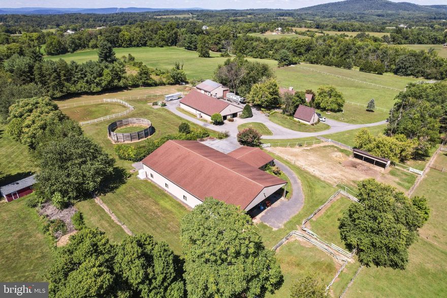 W hat a fabulous  location at the foot of Sugarloaf mountain in the heart of the ag preserve with great views and tranquility!  Ride off property via a quiet rural road.  Enjoy country quiet on just shy of 20 acres with seven fields for your horses.  Eighteen stalls and an indoor too make this a very desirable and versatile  property.  Four outbuildings including a 48x48 work shop and drive through for a large trailer (about 16x48), a detached two car with a loft storage, one 12 stall center isle barn with tack and wash plus attached 50x60'  storage garage for tractor/farm equipment too and another adjacent 6 stall barn; a total of 18 stalls.  This wonderful  property also features a 96x66 lighted indoor arena with tack room.
The home itself features almost 5200 total sq  ft and is finished on all three levels.  It has a walk out basement too.  There are 4 bedrooms and four full baths.   The master suite is on the ground floor, no stairs!
The land may be subdivided for two five acre lots too (family compound?).  There are some existing boarders that can stay or leave with 30 days notice.  Poolesville schools with Monocacy Elementary close by not to mention just a short distance to the MARC train station.