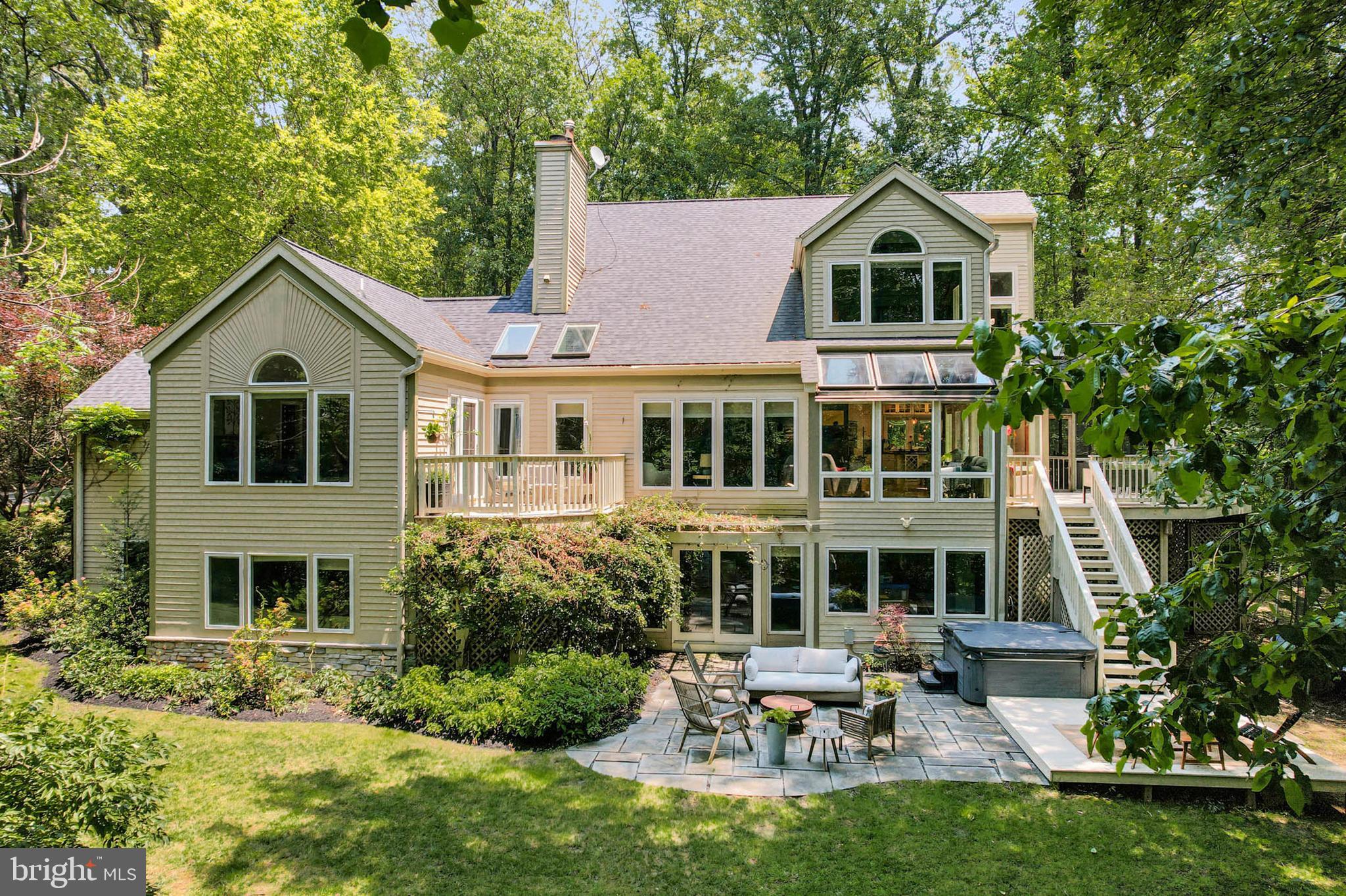 **NEW PRICE** Come home to this tranquil contemporary 5 bedroom, 4.5 bath home in the distinguished and sought-after Wellington neighborhood. Situated on 3.25 mostly-wooded acres, the property feels isolated without being far away. Access the property by way of the winding driveway and you will notice the extensively manicured landscaping leading to the house. Guests approach the inviting front porch featuring a stacked stone façade and rich wood details. The light-filled foyer features gleaming hardwood flooring that extends throughout the open main level. Rich details continue in the living room with exposed beams, a vaulted ceiling and wall of windows, multiple seating areas, and a fireplace with dramatic floor-to-ceiling stacked stone hearth. The dining room has table space for a seating of up to ten. Savor the tastes, flavors, and shared experiences of home cooking in the gourmet eat-in kitchen with custom white cabinetry, high-end stainless steel appliances, granite counters, glass tile backsplash, breakfast bar, and space for a table. A slider leads to the screened in deck that feels like a tree house. The open deck offers plenty of space for grilling and table space for cookouts and crabs while the lower-level deck and patio feature more seating options, space for a firepit, and a soothing hot tub. On the main level, and through the dramatic sitting room with wall-to-wall built-in bookshelves, is the primary bedroom suite with many windows and a private deck to relax with an early morning coffee. The primary suite also features dual walk-in closets and a remodeled super bath with soaring ceiling, dual vanities, a large shower and separate curved tub. Other main level features include access to the oversized two car garage and laundry room with full size washer/dryer for true main level living. The upper-level features two bathrooms and three generously-sized bedrooms, all with vaulted ceilings, large closets and NEW carpeting. The finished lower-level basement also features many windows and a slider to the backyard patio. There is an abundance of storage and the basement rec room features built-ins and a pool table. A home gym and playroom/craft room also have windows facing the beautiful backyard. A fifth bedroom in the basement with its own full bathroom offers privacy for guests, in-laws, or as an office. NEW carpeting was just installed in much of the basement. Many recent updates include an architectural roof installed (2022). Located just south of the I-70 corridor, the property is also close to Route 32. Enjoy the summer in luxury, comfort and style!