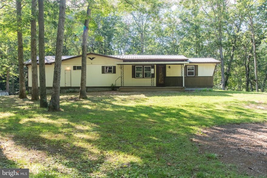 Back on the market, buyer couldn't complete the transaction. Seller is offering up to 50% financing for 5 years at very attractive terms! Lots of space, indoors and out, with this 2 bed, 1.5 bath home. Huge great room addition over 2-car garage with workshop and laundry/ bath/ shower.  All new flooring throughout. Beautiful wooded lot to the rear and mature trees to the front. Large patio with brick BBQ off the great room. RV storage unit is also attached behind the garage for those grand adventures.  Great location, minutes to Fort Ashby and then to Cumberland MD and located in a beautiful setting on a paved road and drive. At last, affordable living with a great location!