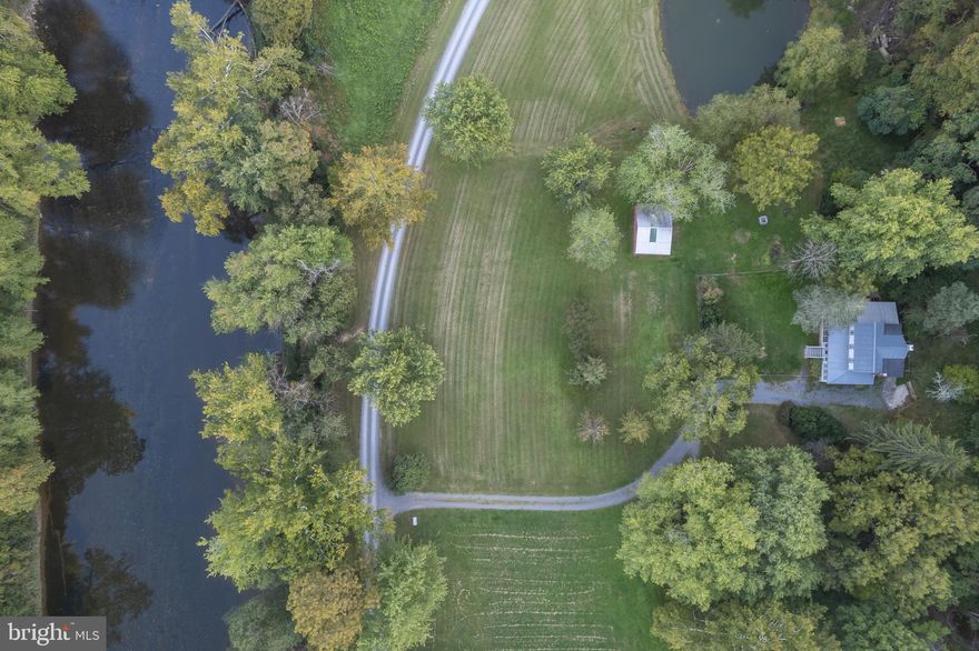 Waterfront paradise that is a perfect getaway or charming full-time home.  This meticulously kept, recently updated 1940's farmhouse sits on 3.25 acres with 300 feet on the beautiful Cacapon River. 4 large bedrooms and 2 full baths with jetted tubs, main level bedroom, living room with new stone fireplace, full kitchen with breakfast bar, large pantry with laundry room and dining room.  You can access the the large screened in porch from the dining room. Upstairs has 3 more bedrooms and a full bathroom.  2020 updates include:  all new paint (interior and exterior), carpets, complete renovation of principal bathroom, updated kitchen with new sink and siltstone countertops and new appliances, stove, dishwasher, microwave, washing and dryer. A new stone outdoor fire pit, new picture windows, new furniture, and all new lighting fixtures and many other updates.  Since 2008 the Sellers have made numerous  upgrades including:  new well, new roof, new HVAC addition of the large screened porch and large exterior deck, outdoor shower and amazing kid tree house.  Spend  your days kayaking, swimming, tubing, fishing for bass, playing lawn games, grilling and roasting smores by the bonfire or just relaxing in an Adirondack chair.  Enjoy your morning coffee on the large screened porch watching the fog lift off the river just steps away and the abundant wildlife (deer, bald eagles, river offers, geese and wild turkeys). The original barn completes this property and provides a great outbuilding with endless possibilities.  Easy access to the river with steps or sit on your deck. 
A shared common area lot is a 10 minute walk up the private road and is a perfect place to drop in your kayaks or tubs and float directly back to the house.