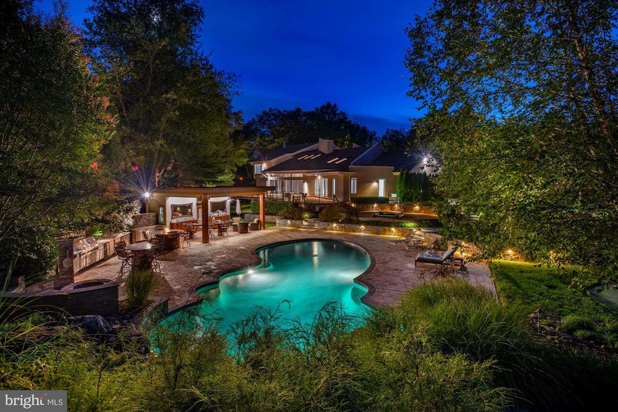 Extraordinary turn-key contemporary sited on 2 private acres in the heart of Potomac. Meticulously updated throughout with attention to detail and lovingly maintained, this exceptional residence offers an open floor plan with cathedral ceilings, sun filled rooms, 4 fireplaces, 3 finished levels, exceptional master bedroom & bath, 3 additional bedrooms and 4 additional bathrooms, and an wonderful private rear yard with stunning pool that has a cascading waterfall & slide, hot tub, pool house with kitchen, extensive entertaining space, putting green, and mature landscaping. The Main level features open public space with cathedral ceilings, formal living room and family room with dual-sided fireplace, updated gourmet-eat in kitchen with custom cabinetry, breakfast area, formal dining room, a full bathroom, laundry and a mud room. The main level is completed by 3 bedrooms, and 2 additional bathrooms.  A loft space above the kitchen offers a fireplace and is perfect for an office. The master suite on the second floor has recently been remodeled and offers cathedral ceilings, fireplace, work area, and luxurious master bath with separate vanities, separate shower, floating tub, additional laundry, and 2 walk-in closets.   The expansive walk-out lower level offers a recreation area, living area with fireplace, exercise room, ample storage, and a handsome theater room with bar seating, kitchen, and full bathroom.  This room can easily be converted into a 5th bedroom or in-law suite.   The property is completed by an attached 3-car garage. The grounds offer mature landscaping providing for wonderful privacy.  The large open yard with putting green is perfect for playing or entertaining.  The pool with cascading waterfall, diving rock, slide, and beach entry is perfect for enjoying summer days.  A pool house offers full kitchen, grilling station, 2-firepits, counters, pizza oven, ample storage, and so much more.  A hot tub off the expansive rear deck completes the pool area.  A perfect getaway right at home.  Truly a must see.   Just minutes away from to the shops and restaurants of Potomac Village and a easy access to the Capital Beltway (I-495), Clara Barton Parkway, I-270, Northern Virginia, downtown Washington, DC, and all of the Capital Regions airports.