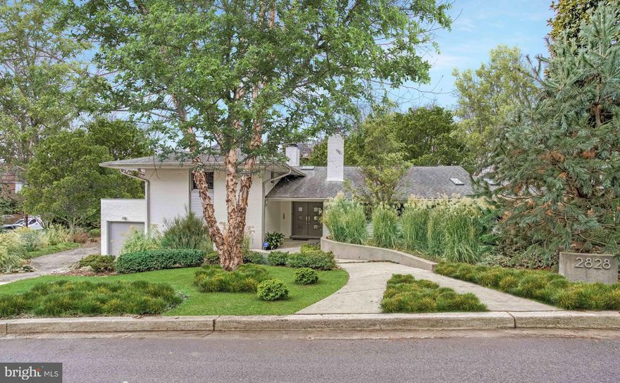 Nestled on a lushly landscaped corner lot on tree-lined Brandywine Street, this stunning mid-century modern home effortlessly blends timeless design with contemporary comfort. Offering four spacious bedrooms and three and a half bathrooms, this property is an ideal sanctuary for modern living and entertaining. Designed by notable Washington architect Joseph Miller, FAIA, the home’s architectural pedigree is immediately evident with its clean lines, expansive south-facing windows, and seamless integration with the surrounding natural beauty.
Step inside to discover a bright and airy interior, with an open-concept layout that features floor to ceiling glass, gleaming hardwood and slate floors, multiple skylights, and generous living spaces bathed in natural light. The gourmet kitchen, renovated in 2020 and outfitted with top-of-the-line stainless steel appliances, sleek cabinetry, and quartz countertops, is a chef’s dream, perfect for hosting intimate dinners or lively gatherings. Adjacent to the kitchen, the dining area flows into the living room, complete with an Alicante marble surround gas fireplace and views of the California-like, private backyard, 38 foot salt water pool with automatic cover, and extensive hardscaping. 
The primary suite serves as a tranquil retreat, featuring a spa-like en-suite bathroom renovated in 2019 with separate shower, heated terrazzo floor, soaking tub, and ample closet space. Three additional bedrooms, each generously sized, and three additional bathrooms ensure comfort and privacy for family and guests alike. A large, lower-level recreation room offers direct access to the garage and rear yard. A den on the main living level is perfect for movie watching or relaxing with family and friends.
Outdoor living is equally captivating, with the gas-heated pool, spacious patio and landscaped yard with in-ground sprinkler system offering a serene escape for relaxation, gardening, or al fresco dining with built-in under-eave heating. Accessed by a large permeable driveway that can accommodate several cars, the heated attached 2 car garage built in 2014 is outfitted with a Chargepoint Level 2 EV charger and the finished space with epoxy floor and oversized sliding glass doors can double as a gallery-sized entertainment space.   Above the garage, a green roof is one of several eco-friendly features. Solar panels add to the home’s environmental sustainability along with custom low EV windows throughout. Ample storage throughout the home adds to its practicality and convenience.
Located in the highly sought-after Forest Hills neighborhood, this property is just minutes from Rock Creek Park, Van Ness Metro (Red Line), esteemed public and private schools, embassies, vibrant dining, and easy access to downtown DC. Don’t miss the opportunity to own this architectural masterpiece that offers the perfect balance of style, space, and location.