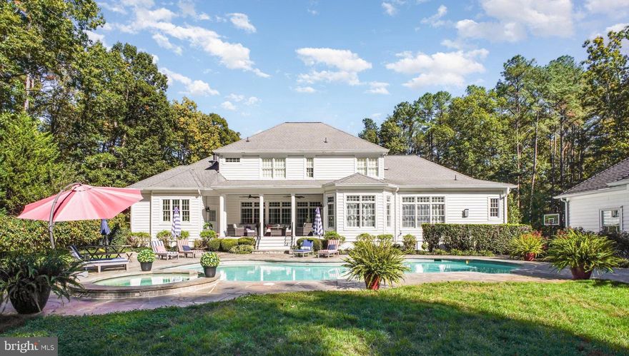 Presenting an exclusive Fawn Lake estate, an architectural masterpiece on over 3 wooded acres, this is a private resort-style retreat complete with a custom swimming pool and koi pond. Situated in the gated community of Fawn Lake, this executive property is designed for both grand entertaining and comfortable daily living. From the stately circular driveway framed by flowering trees to the striking façade with double mahogany doors and stacked porches showcasing custom designed wrought-iron railings, this home makes a lasting first impression.
Inside, a dramatic two-story foyer with sweeping staircase and architectural detailing sets the tone for timeless sophistication. The formal dining room features exquisite trimwork and walls of Anderson windows ideal for hosting gatherings, while the living room showcases a fireplace and panoramic views of the landscaped gardens and pool. The recently remodeled gourmet kitchen includes custom soft-close cabinetry, quartzite counters, marble backsplash, designer lighting, touchless fixtures, and top-tier Wolf appliances throughout. A large center island with prep sink, wine fridge, and ice maker connects seamlessly to the bright breakfast area and family room, which is highlighted by soaring windows and a dramatic stone fireplace. The main-level owner’s suite offers a sitting area, dual walk-in closets, and a recently meticulously renovated spa-inspired bath with soaking tub, oversized shower, and private access to the rear veranda.
Upstairs, two expansive bedroom suites with en-suite baths and French doors to the front porch, plus a third en-suite bedroom with walk-in closet, provide ample living space. The lower level has been recently remodeled with luxury vinyl plank flooring and a custom wet bar by Fraser Wood Elements. This open-concept area includes a recreation room, game room or optional bedroom, den, full bath, and abundant storage—ideal for entertaining.
The backyard offers a private resort designed for year-round enjoyment, featuring a heated pool with spa designed by Sylvan Pools, flagstone terraces, outdoor dining patios among gardens and stone courtyards, and a custom koi pond with waterfall and more than 30 koi. Professional landscaping includes ornamental plants, flowering trees, raised vegetable beds, and custom exterior lighting with four low-voltage zones. The estate includes a three-car attached garage plus a separate detached 30-foot garage and pool house with full bath. Sprinklers and Pool are supported by a 150-foot deep well with high-pressure pump and 22 irrigation zones with more than 50 sprinkler heads and 8 soaker beds.
Recent updates ensure modern comfort and efficiency, including fully upgraded dual-zone HVAC systems with new attic and basement furnaces, a brand new 2024 Generac whole-home generator with Bluetooth and WiFi, resurfaced garage flooring with a 9K lbs. lift, updated pool and koi pond systems, a Tesla 200-amp home charging station in the detached garage, and enhanced landscaping with new trees, shrubs, lighting, and a backyard firepit.
A partial golf membership to Fawn Lake Country Club conveys with the property, providing access to a private lake with marina and beach, championship golf course, tennis and pickleball courts, walking trails, fitness center, sports fields, dog park, restaurants, and a vibrant social club—all set near Fredericksburg, wineries, farm markets, and award-winning breweries.