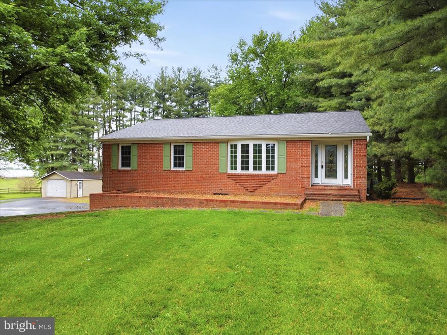 Welcome to the perfect blend of country charm and everyday convenience. This beautifully maintained 3 bedroom, 2.5 bath brick ranch sits on a cleared 0.97-acre lot, offering privacy, space, and scenic views backing to farmland. Originally built in 1983 and offered by the original owner, this home checks all of the boxes. Inside, you’ll find a functional layout featuring a stunning remodeled kitchen (2026), a large dining room, a formal living room, and a versatile space, perfect for a home office or welcoming foyer. The primary suite bathroom includes an updated walk-in shower and a secondary laundry hook-up. Hardwood and carpet flooring (2022) add warmth and comfort throughout. Adding even more options, this home features a thoughtful addition, which includes a bright family room, a convenient second laundry area, a half bath and a separate entry.  This area is ideal for flexible living arrangements or for extra room to entertain or relax. The partially finished lower level offers so many possibilities. This area features flex space perfect for hobbies, living space, storage, or a home gym - there's even a wet bar. An oversized two and a half car garage and baseboard heat, add functionality and convenience.  Comfort and peace of mind are abundant with upgrades including a new roof (2019), updated appliances (within the last few years), a new HVAC system (2025), updated tilt-in windows (2011), and a water treatment system, with a softener and neutralizer. This home is truly move in ready.  Outside, the property truly shines. Enjoy the expansive yard with mature trees along the rear and side boundaries, perfect for watching the wildlife or just enjoying the breeze on the covered back porch. The view through the trees, is like a hidden gem, fields and mountains as far as you can see. This property boasts two large sheds (built in 2000 and 2015) with electricity, a gravel area with RV hookup and abundant parking on the recently repaved driveway (2022). Other notable mentions include a recent well pump upgrade (2022), septic pumping and overall maintenance.  Enjoy the tranquility of country living with the convenience of nearby amenities just a short drive away. This property offers the space, updates, and versatility you’ve been looking for, don’t miss your chance to call it home.