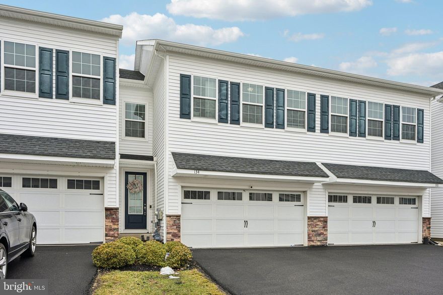 Welcome to this beautiful 3-year-young townhome in the desirable Southall community, offering modern design, generous living space, and a prime location near parks and recreation. Enter inside to the foyer that welcomes you into the open-concept main level. The living room, dining area, and eat-in kitchen flow seamlessly together to create a bright and inviting great room, highlighted by attractive vinyl flooring throughout. The kitchen is truly the heart of the home, featuring a huge center island with seating, elegant granite countertops, stainless steel appliances, abundant cabinet and counter space, and a large pantry—perfect for everyday living and entertaining. Sliding glass doors off the dining area lead to the extended rear deck overlooking open space, providing the perfect setting for relaxing or outdoor dining. A convenient half bathroom and access to the two-car garage complete the main level. Upstairs, a spacious landing offers incredible flexibility and is ideal for a sitting area, reading nook, or home office. The primary suite, tucked behind elegant double French doors, features two walk-in closets and a beautifully appointed ensuite with a dual vanity, glass-enclosed walk-in shower, and private water closet. Two additional well-sized bedrooms, each with walk-in closets, share a full hall bathroom, and the laundry room is conveniently located on this level. The full basement provides endless potential—finish it to create additional living space such as a recreation room, gym, or media room, or use it for plentiful storage. This home also enjoys an excellent location just a short distance from Manderach Park, a 70-acre park featuring a playground, pavilions, pickleball courts, tennis courts, bocce courts, softball and baseball fields, sand volleyball courts, basketball courts, and scenic walking and running trails. Move-in ready and thoughtfully designed, this home offers the perfect blend of modern comfort, space, and convenience. Mortgage savings may be available for buyers of this listing.