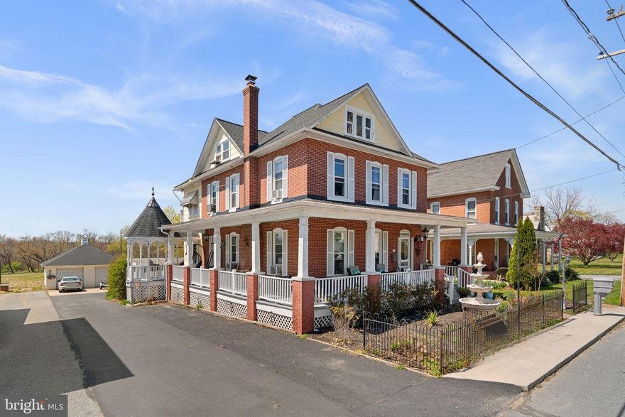 Step into timeless elegance with this classic 1912 all-brick Colonial, perfectly situated on a spacious quarter-acre lot in desirable Hampstead, Carroll County. This charming home blends historic character with thoughtful modern updates, offering 4 bedrooms and 1.5 baths.

Enjoy relaxing mornings on the inviting wrap-around porch or unwind in the beautifully landscaped yard featuring mature greenery, a gazebo, pergola, and a fully fenced backyard—ideal for entertaining or private outdoor living.  Spacious 2 car garage and shed

Inside, you’ll find a stunning combination of original charm and upscale finishes, including classic hardwood floors, designer tile in the entryway and kitchen, and unique stenciled flooring on the second level. The updated kitchen is a chef’s dream, boasting marble countertops, a 6-burner gourmet gas stove, and a cozy gas fireplace.

The home has been thoughtfully updated with modern plumbing and electrical systems, along with a brand-new roof on both the main house and garage. The spacious living area is anchored by a large stone fireplace with a new liner, perfect for gathering on cooler evenings.

Additional highlights include a fully finished attic offering versatile space for a sitting area, bedroom, or office, as well as convenient second-floor laundry with a brand-new washer and dryer that convey.

A rare opportunity to own a piece of history with all the modern comforts—this Hampstead gem is truly one-of-a-kind.